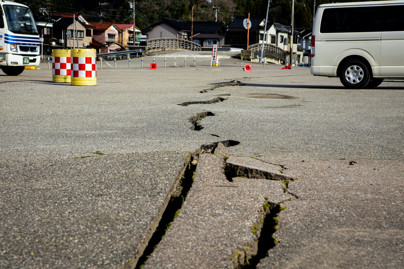 Cracked pavement with vehicles and surrounding scenery