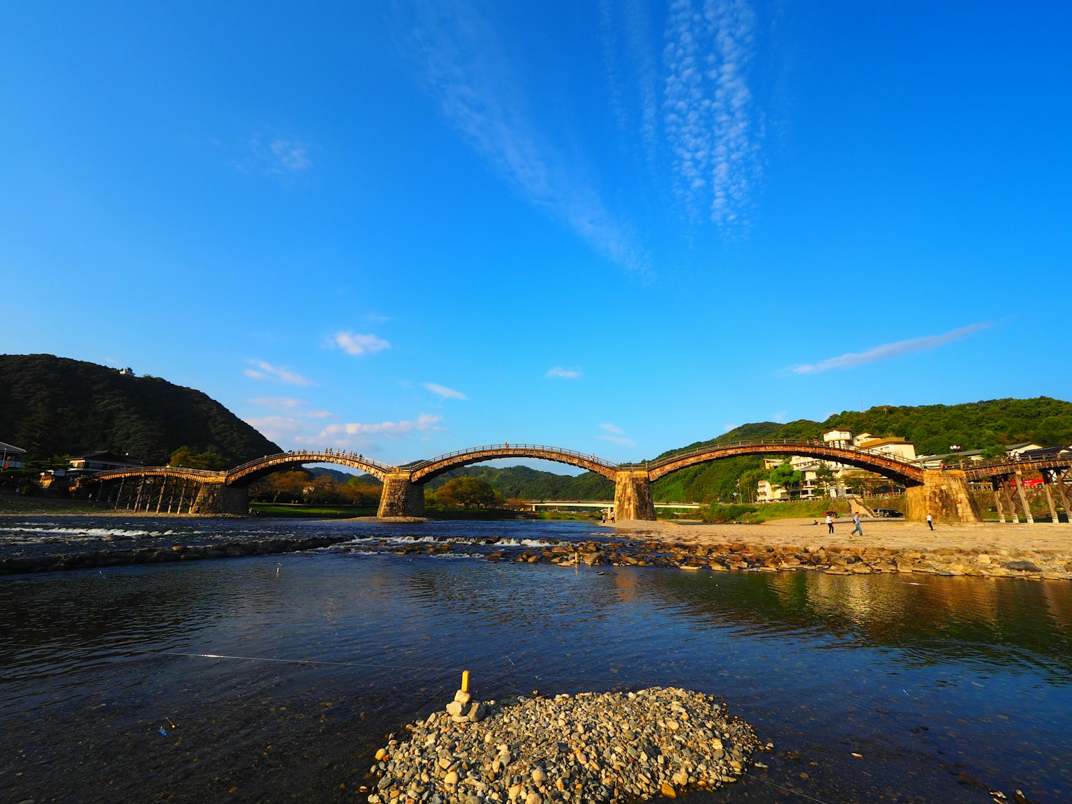 Vue pittoresque d'un pont en arc sur une rivière sous un ciel bleu clair