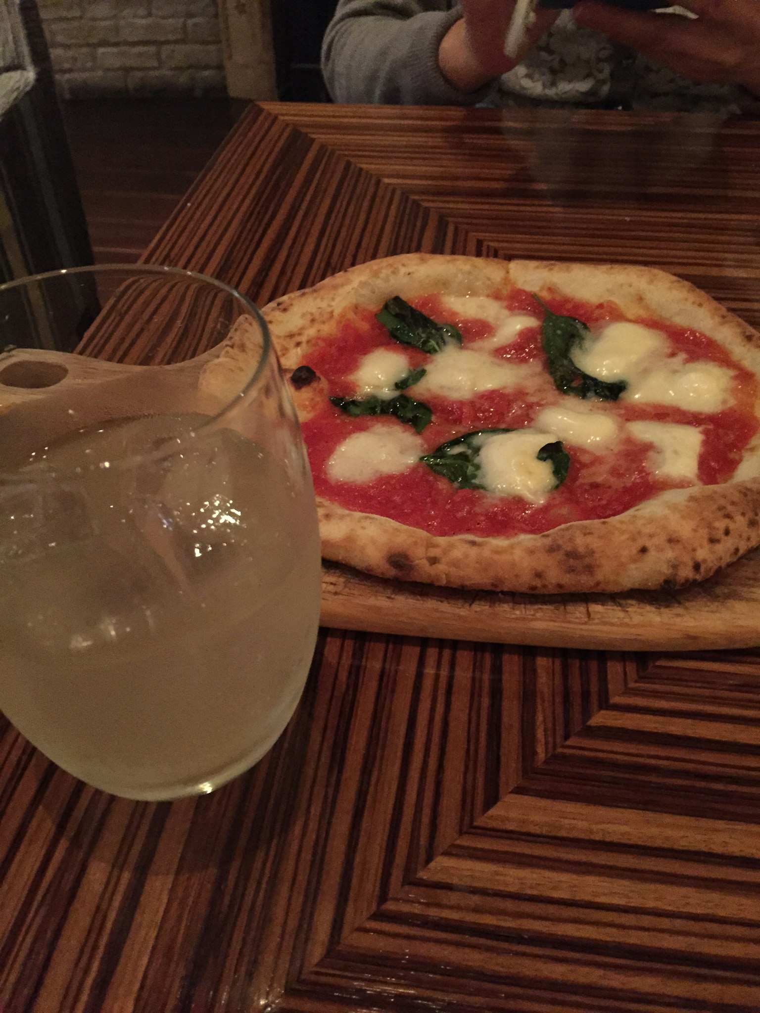 Pizza Margherita su un tavolo di legno con una bevanda