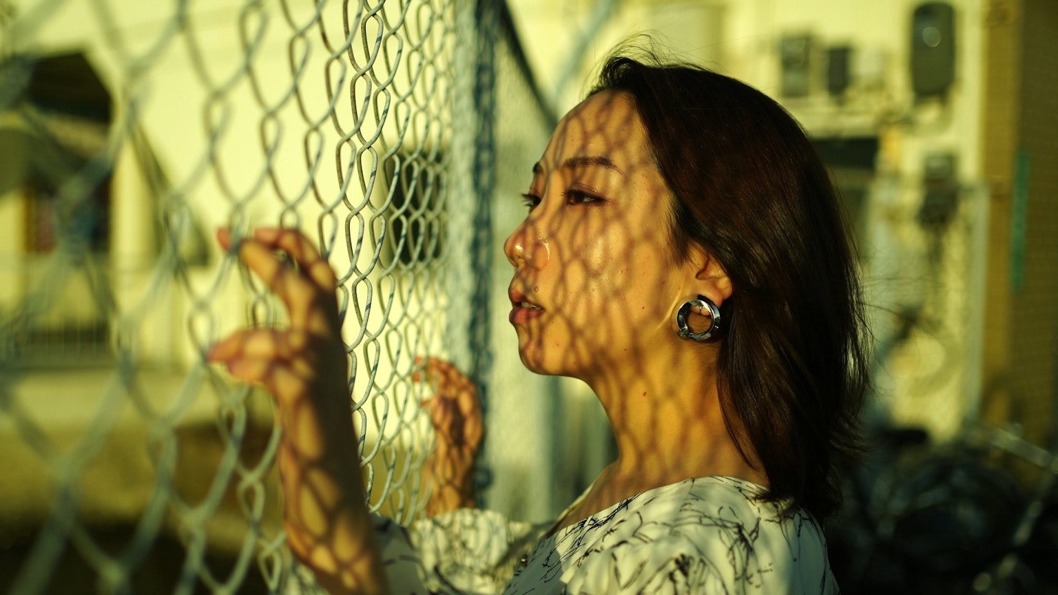 栅栏后面的女人，脸上投射阴影