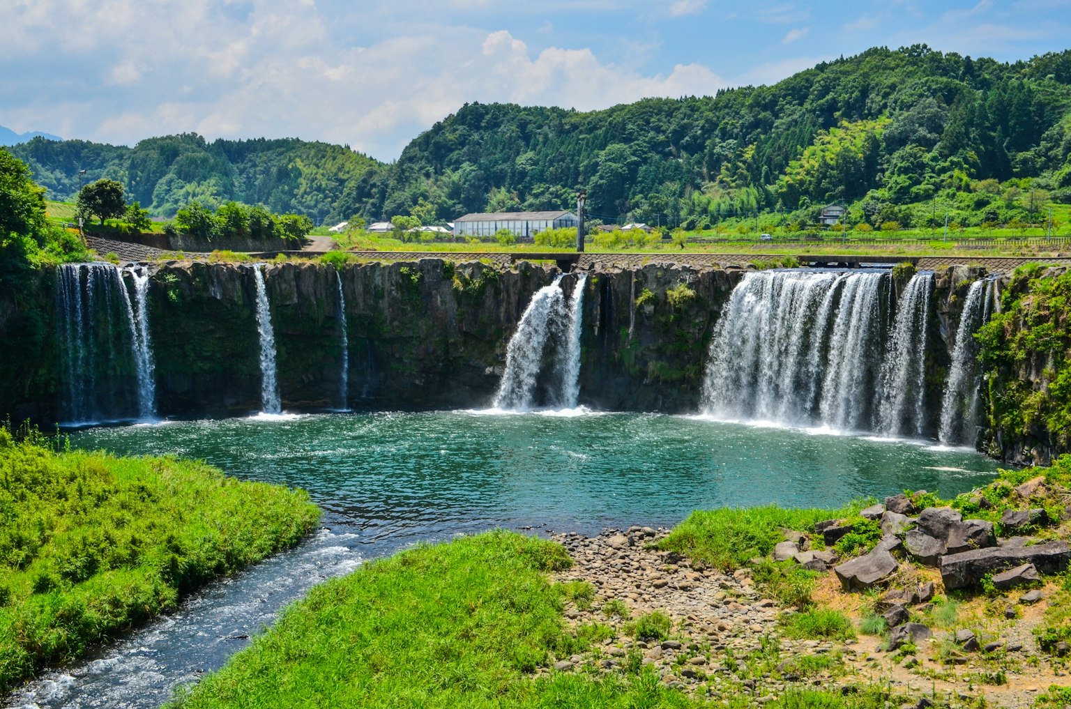 Una vista panoramica con belle cascate e uno stagno blu chiaro