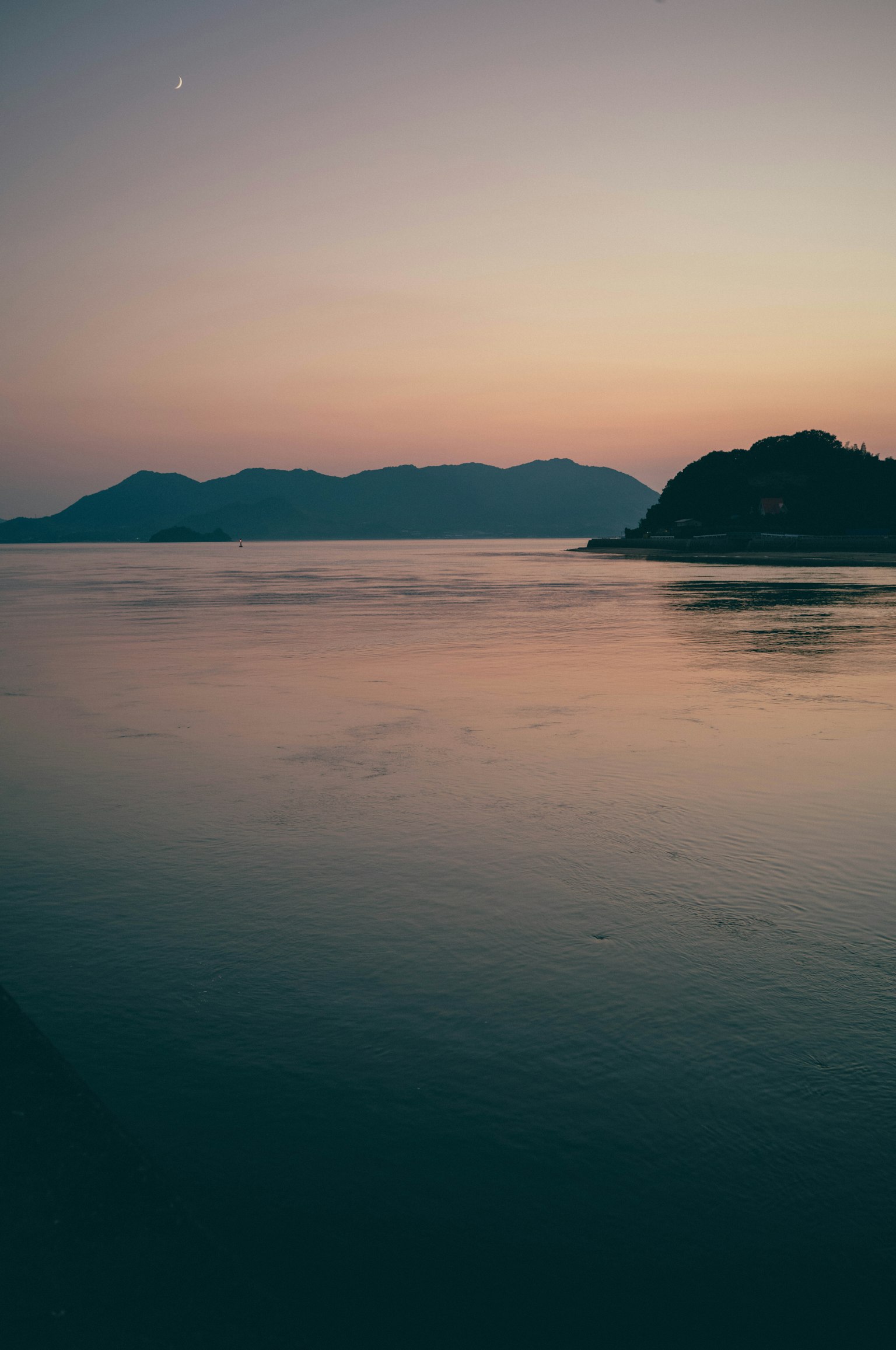 평화로운 일몰 풍경과 고요한 물과 산의 실루엣