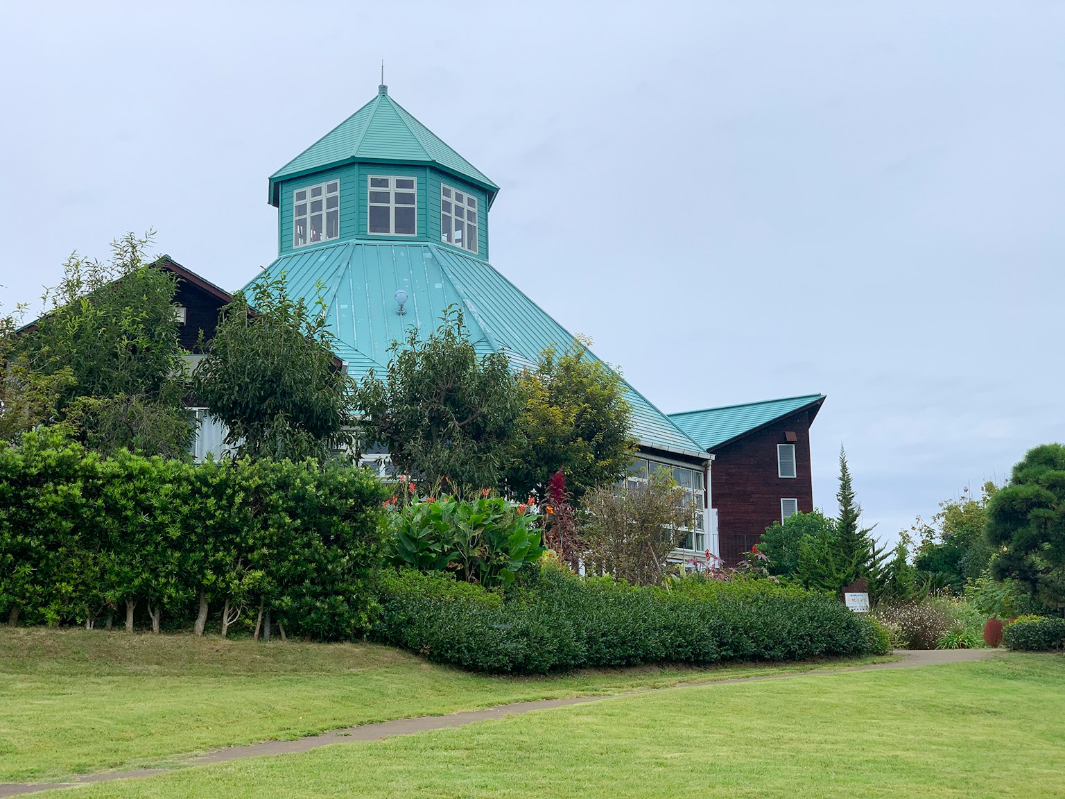 Edificio unico con un tetto verde circondato da un giardino