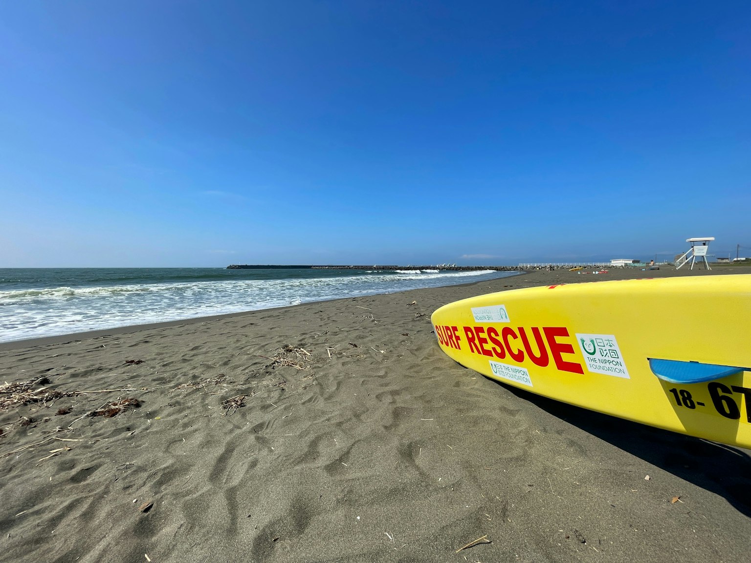 Papan penyelamat kuning di pantai dengan langit biru