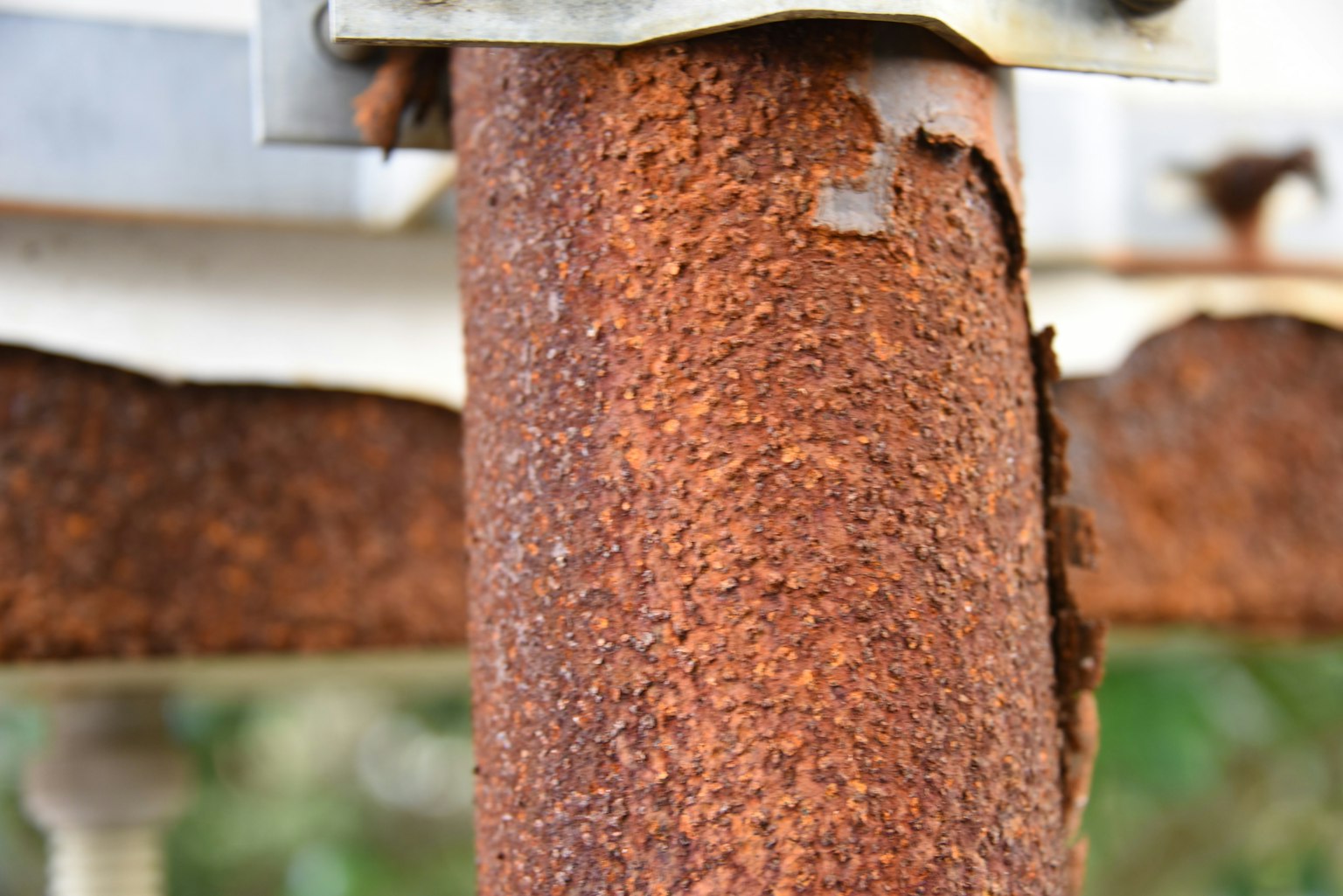 Acercamiento de un poste metálico oxidado que resalta su textura y color