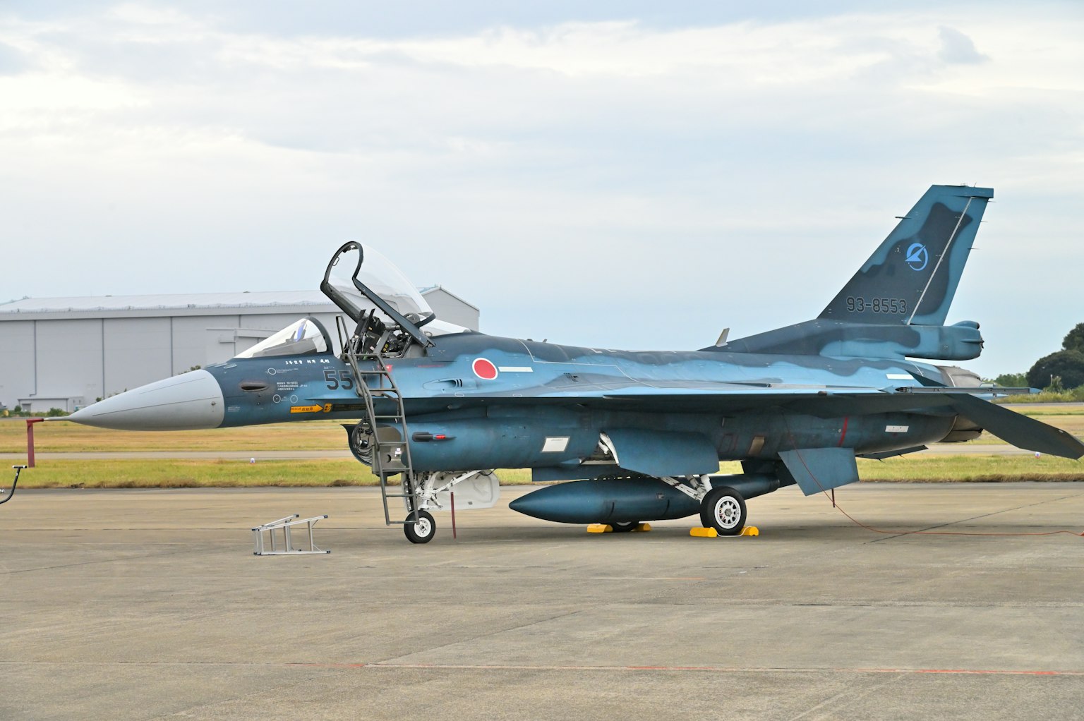 Avion de chasse F-2 peint en bleu stationné sur la piste