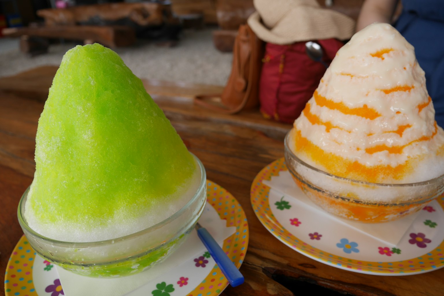 Green and orange shaved ice served in bowls
