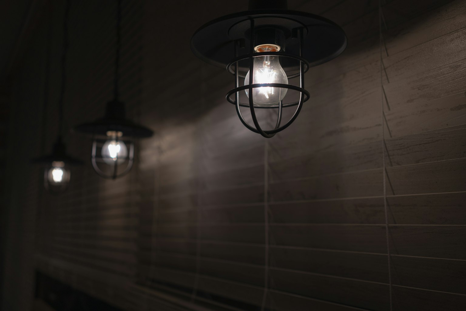 Lampes suspendues rétro émettant une lumière chaleureuse dans un cadre sombre