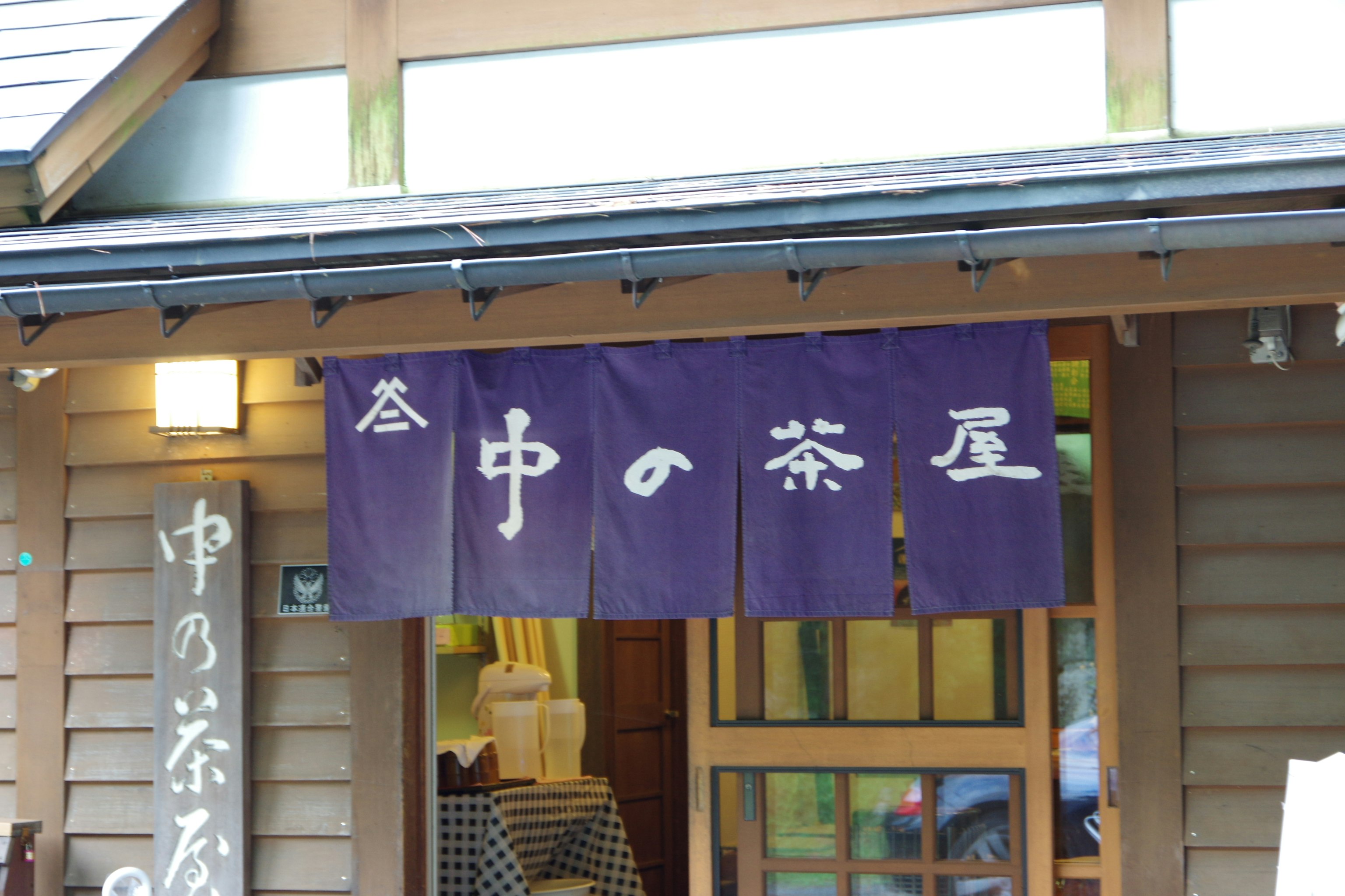 หน้าร้านญี่ปุ่นพร้อมผ้าผ่าน (noren) ที่เขียน “Naka no Chaya”