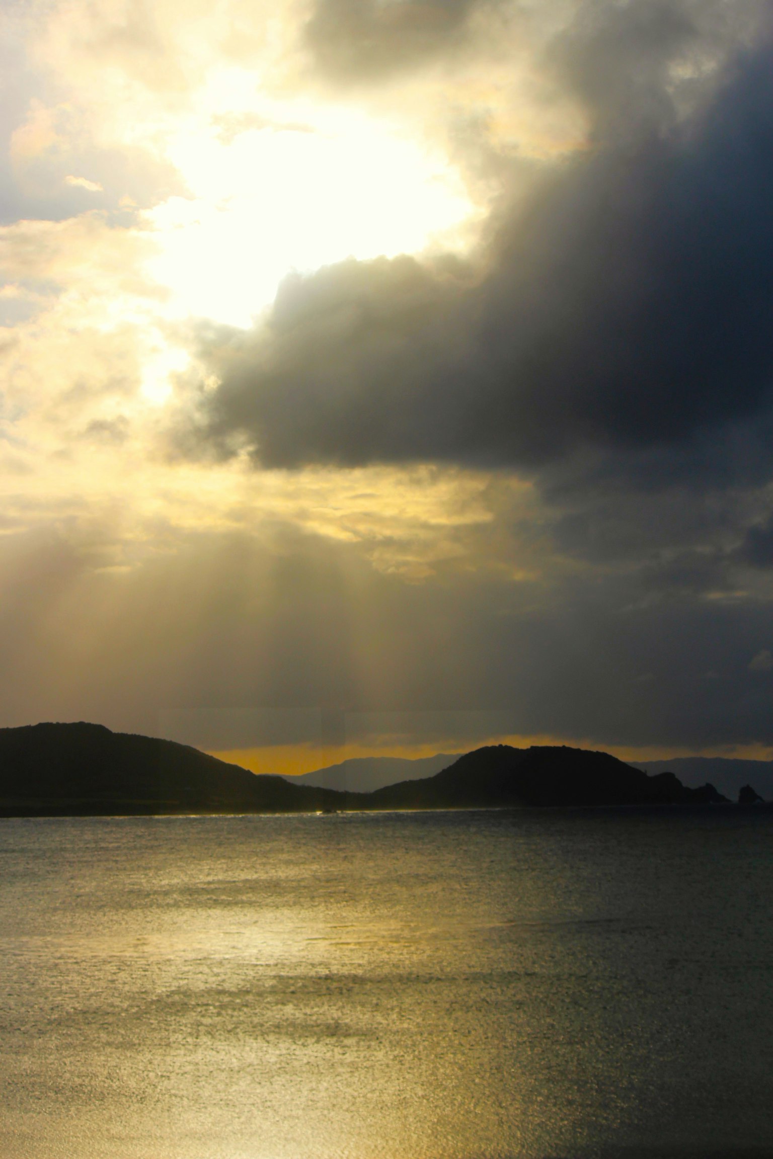 Paesaggio marino al crepuscolo con isole e luce che penetra tra le nuvole