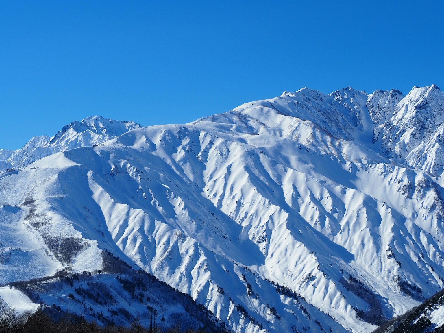 Paysage de montagnes enneigées sous un ciel bleu clair