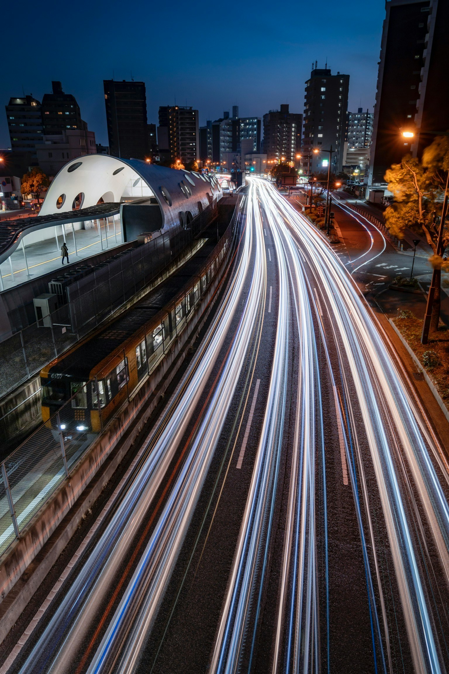 Paysage urbain de nuit avec des traînées lumineuses de voitures en mouvement