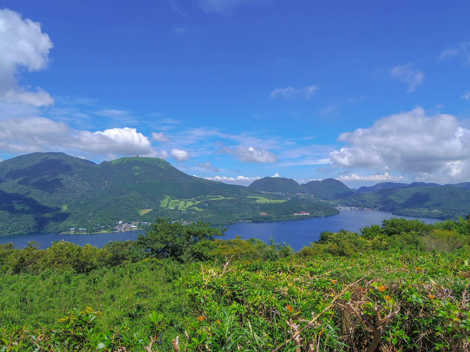 Pemandangan indah pegunungan dan danau pepohonan hijau dan langit biru