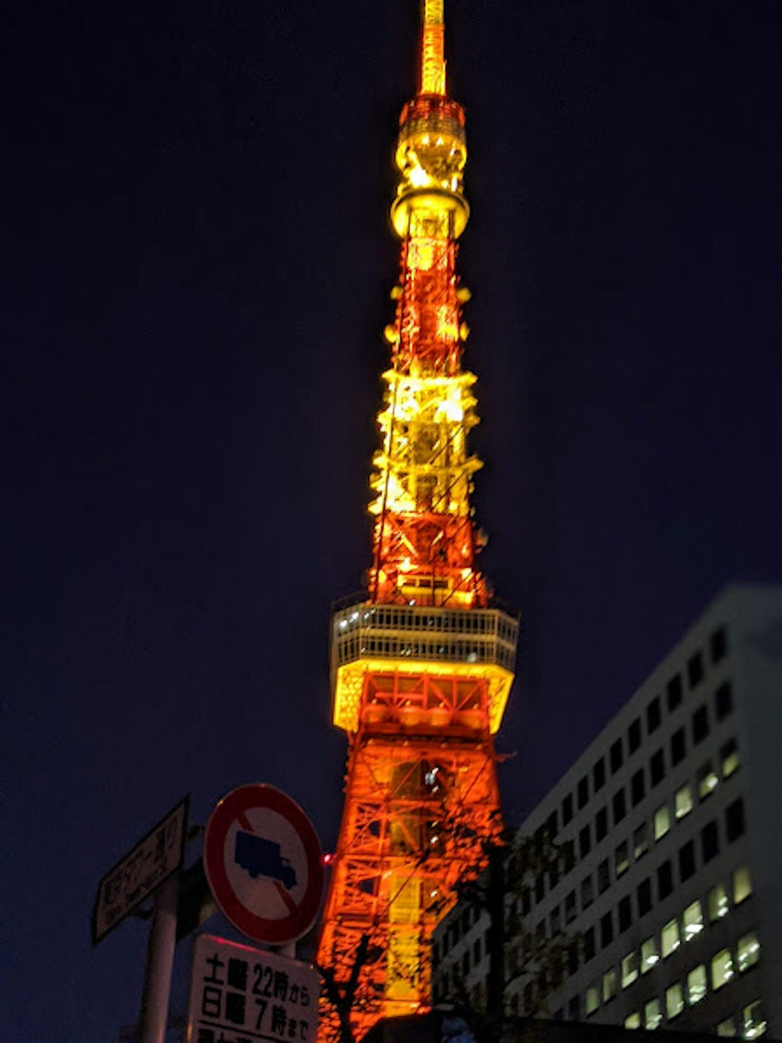 Tokyo Tower illuminated in orange and yellow at night