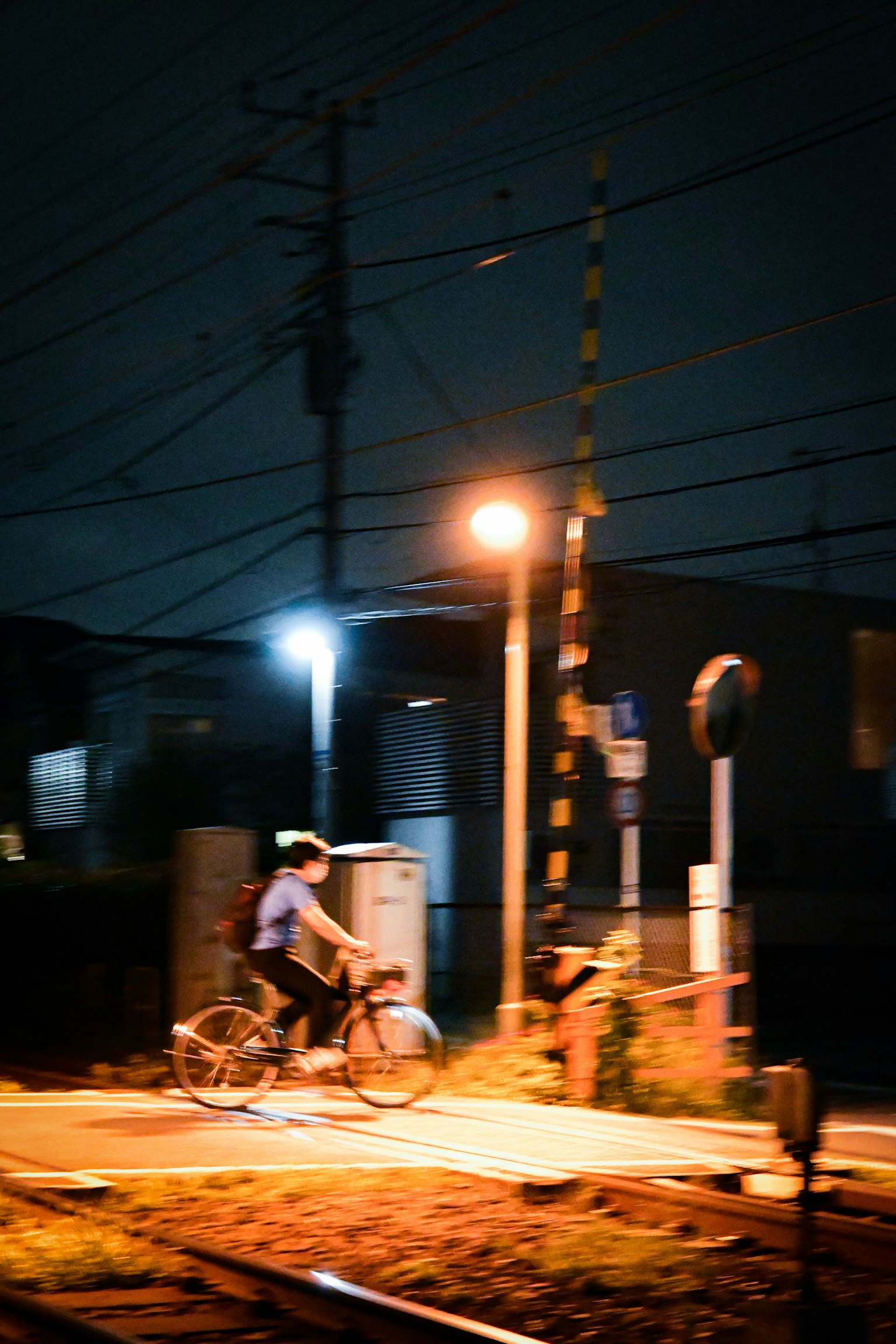 Una persona montando una bicicleta en la noche con farolas