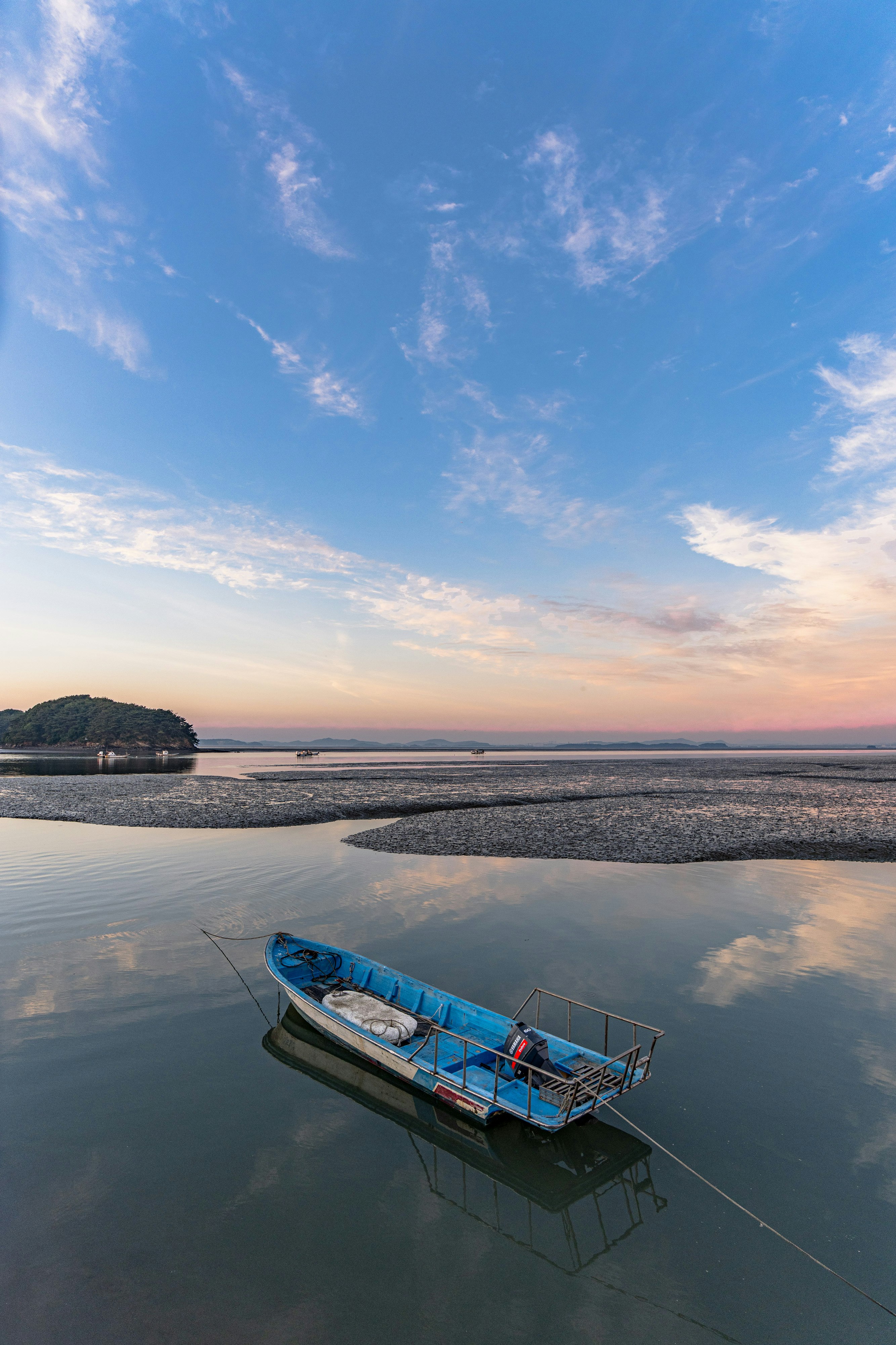 黃昏時平靜海灣裡漂浮的船