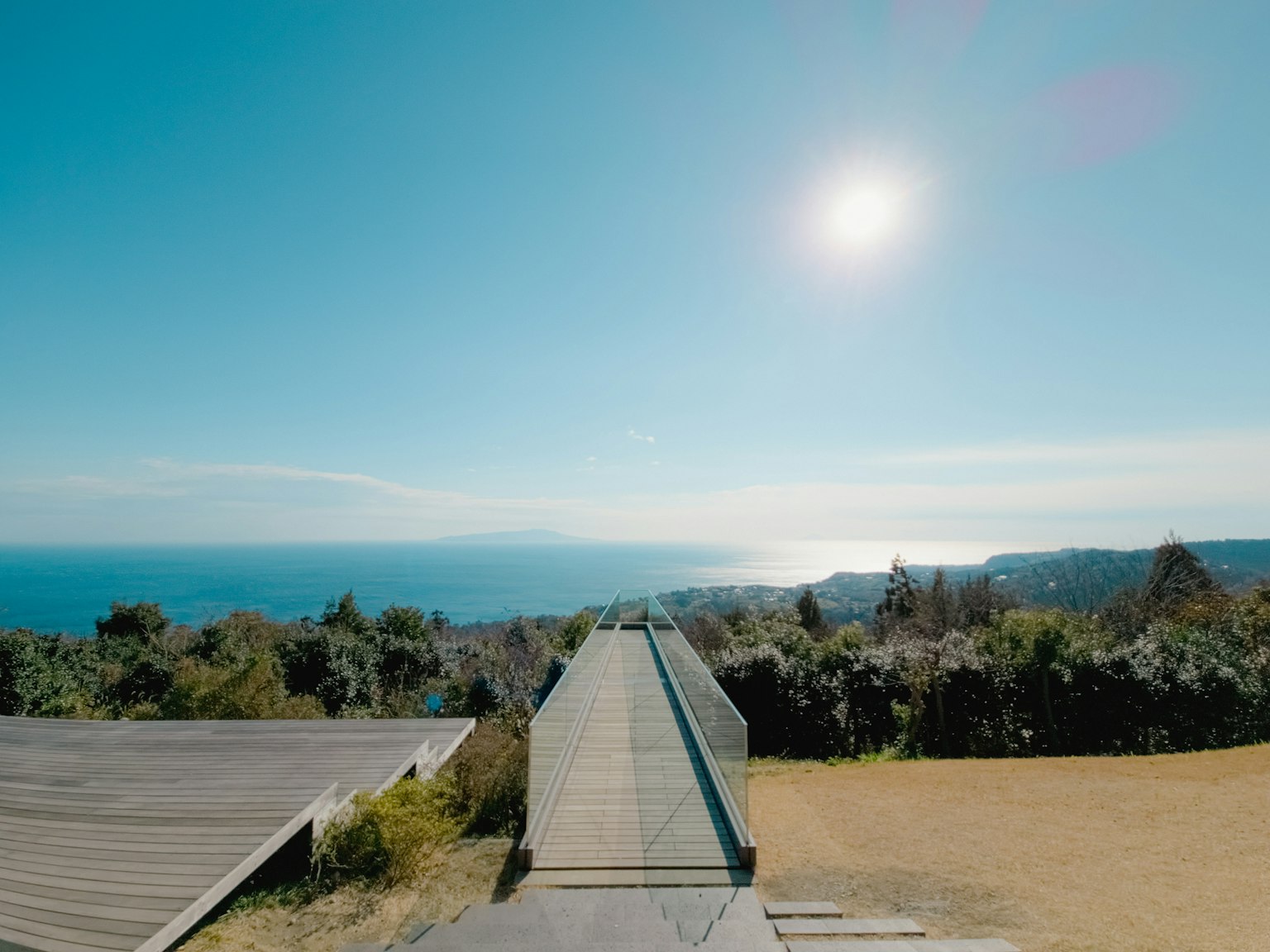 Vue expansive sur l'océan sous un ciel bleu clair avec un chemin