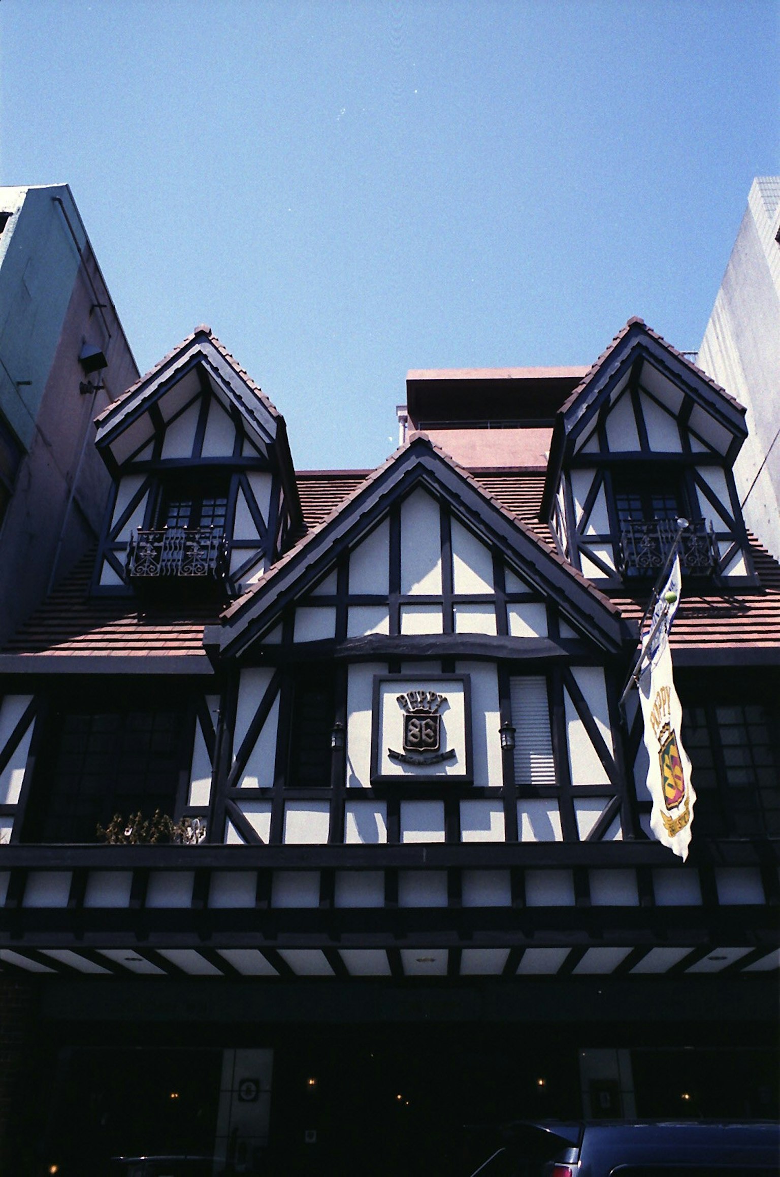 Traditional style building with black and white timber framing under a blue sky