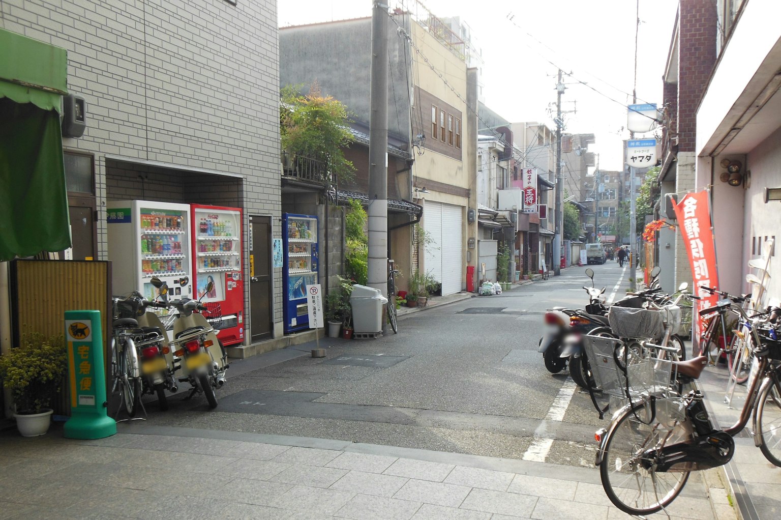 Ruhige japanische Gasse mit geparkten Fahrrädern und einem Verkaufsautomaten