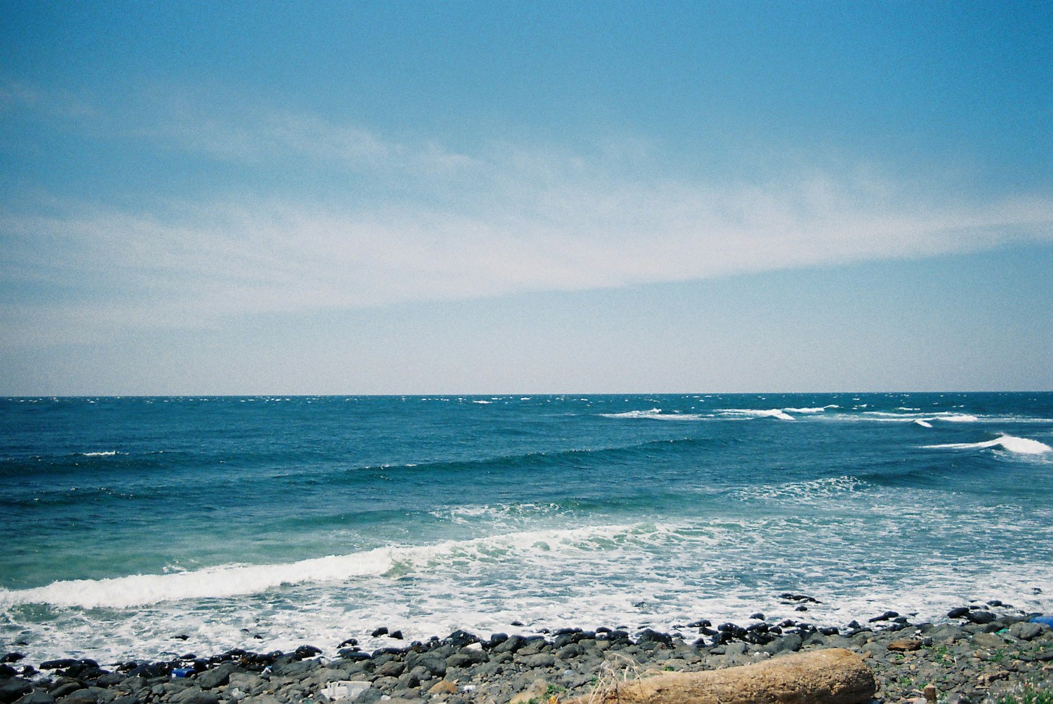 Coastal landscape featuring blue ocean and white waves