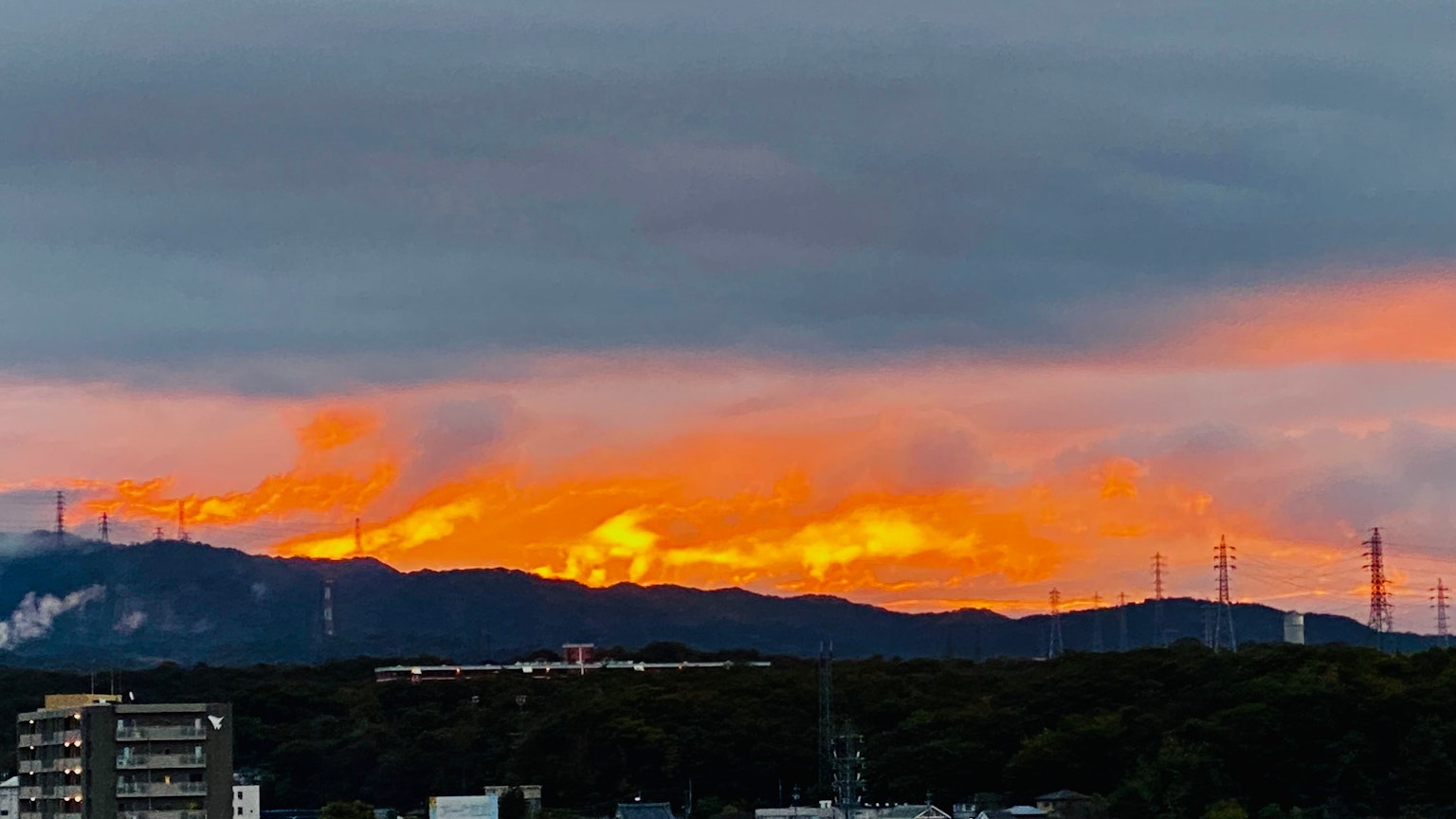 日落時的山景，橙色和灰色的雲彩