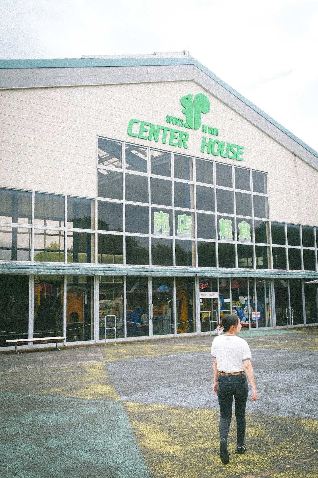 outdoor scene with a person walking in front of the “CENTER HOUSE” building in Chichibu