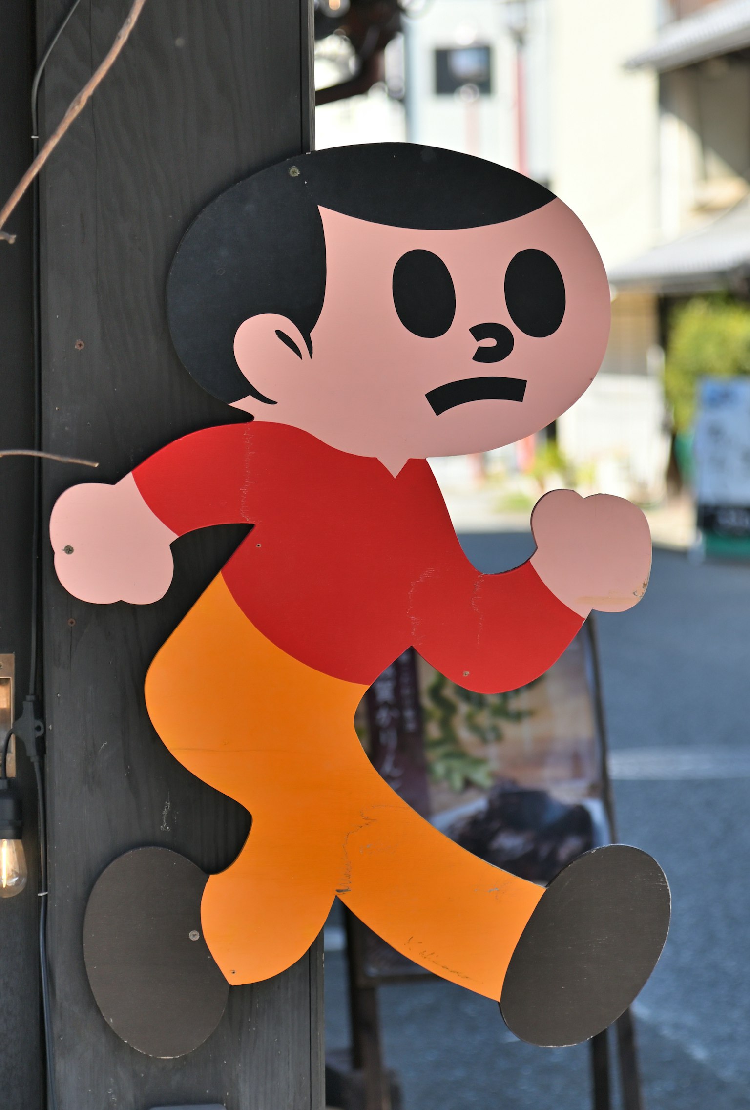 Cartel de un personaje corriendo con una camiseta roja y pantalones naranjas