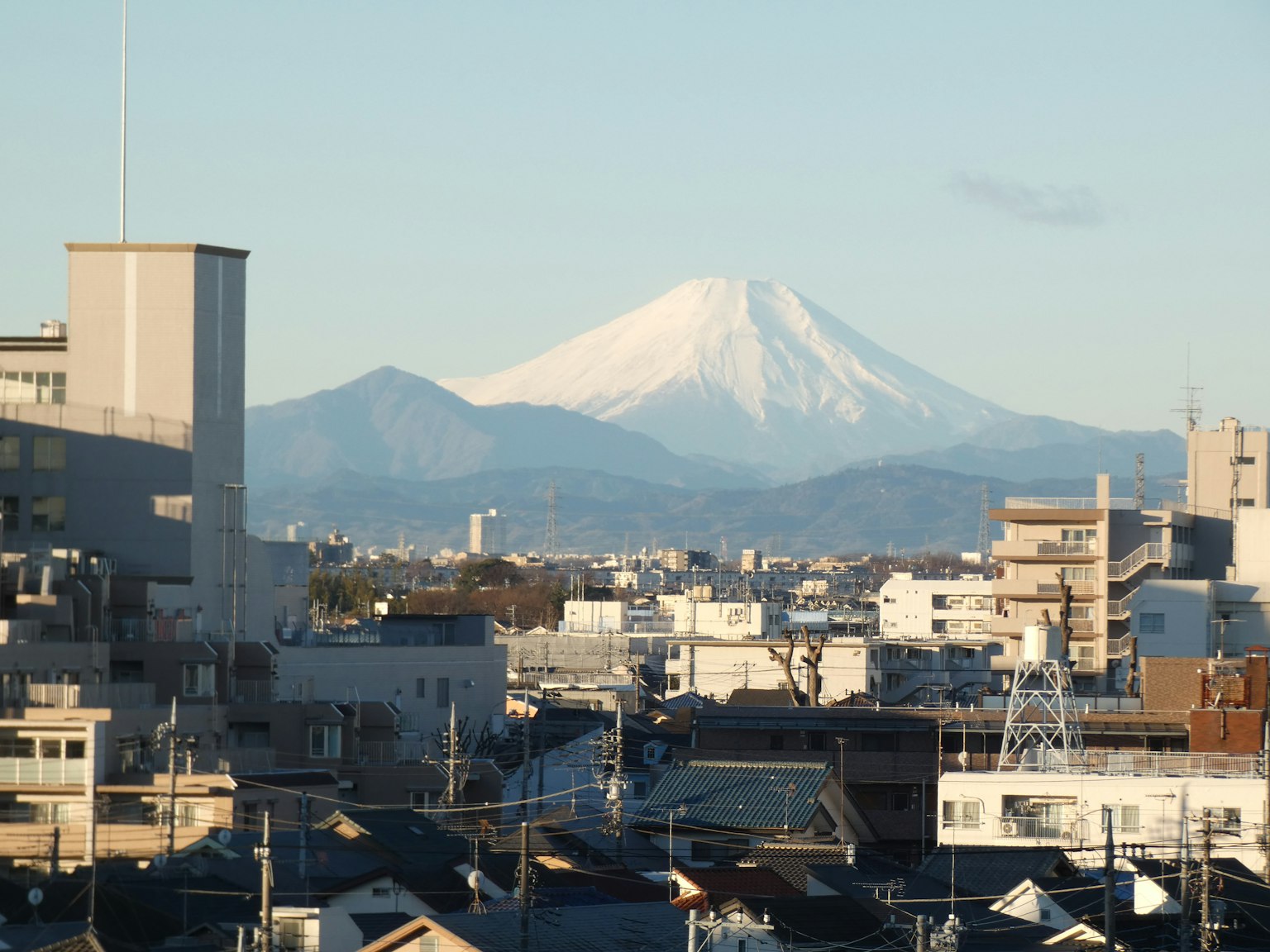 Stadtansicht mit schneebedecktem Fuji im Hintergrund