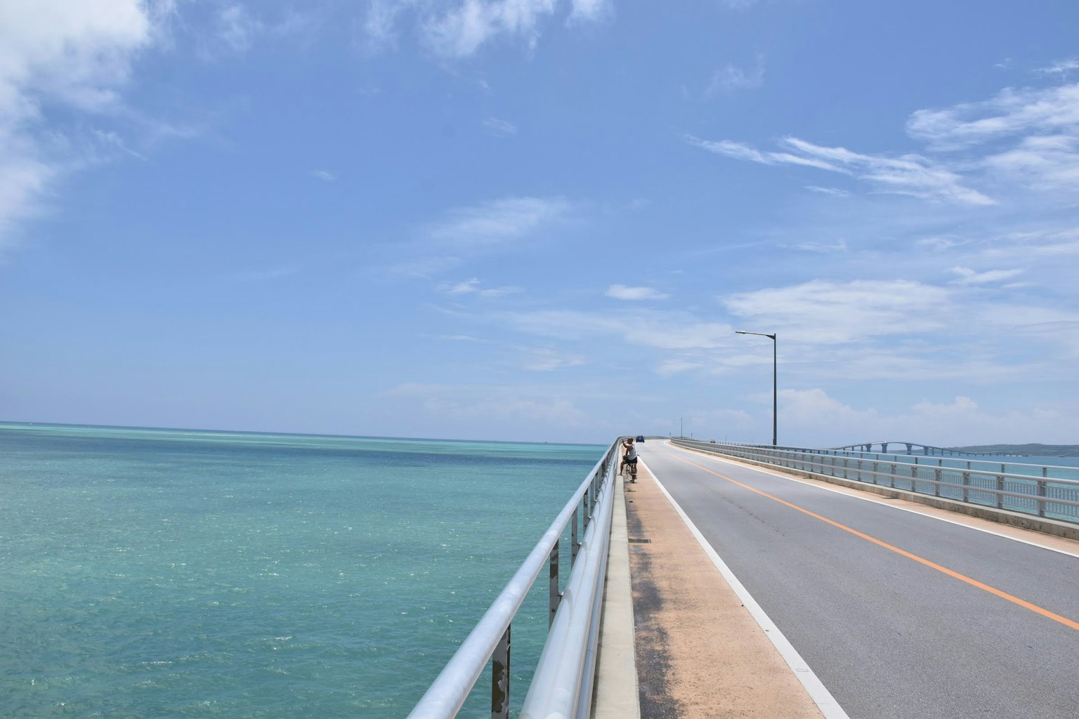 ทิวทัศน์ของสะพานยาวเหนือทะเลสีฟ้าใสใต้ท้องฟ้าสีฟ้า