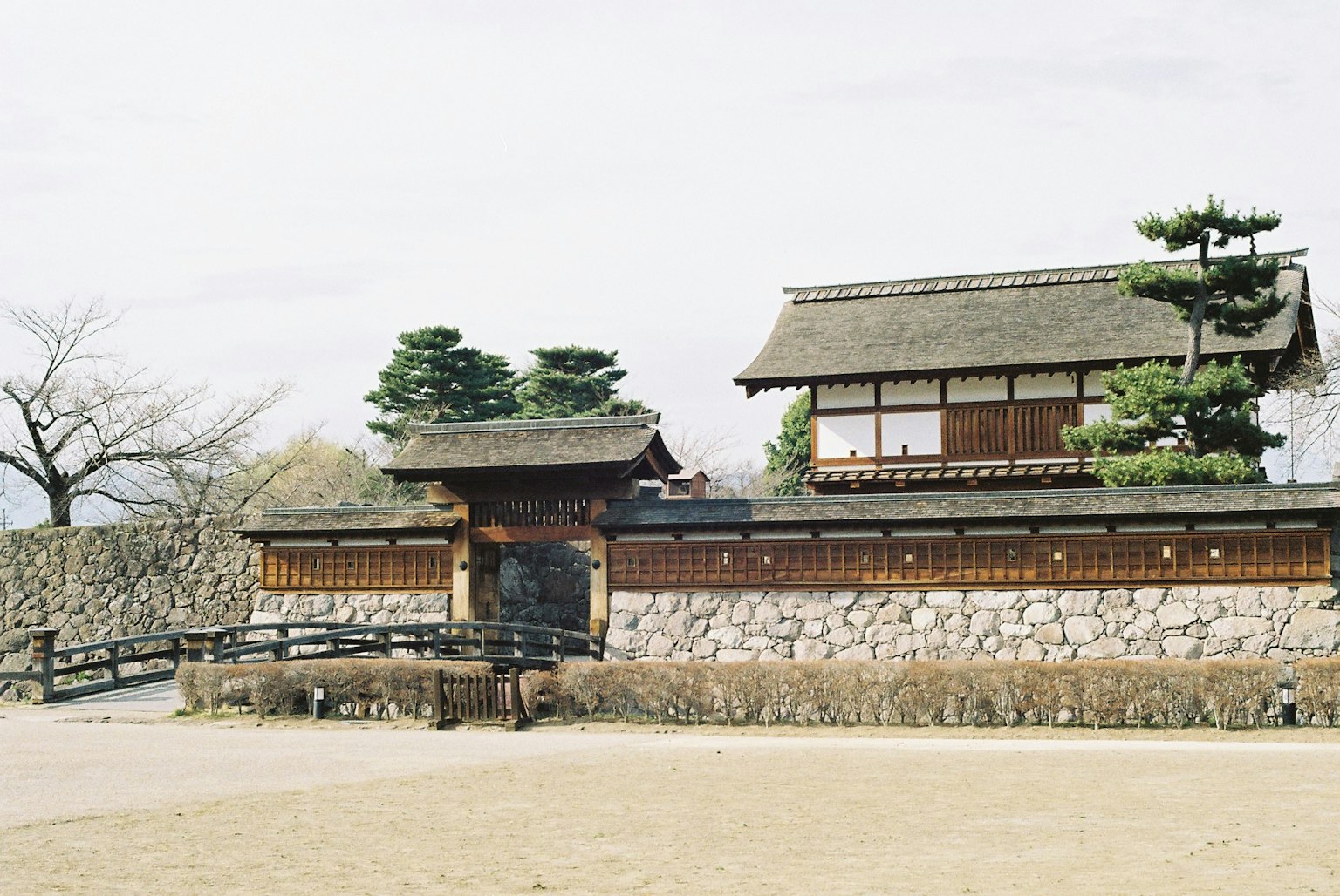 Traditionelles japanisches Schlossportal mit Holzgebäude und Steinmauer