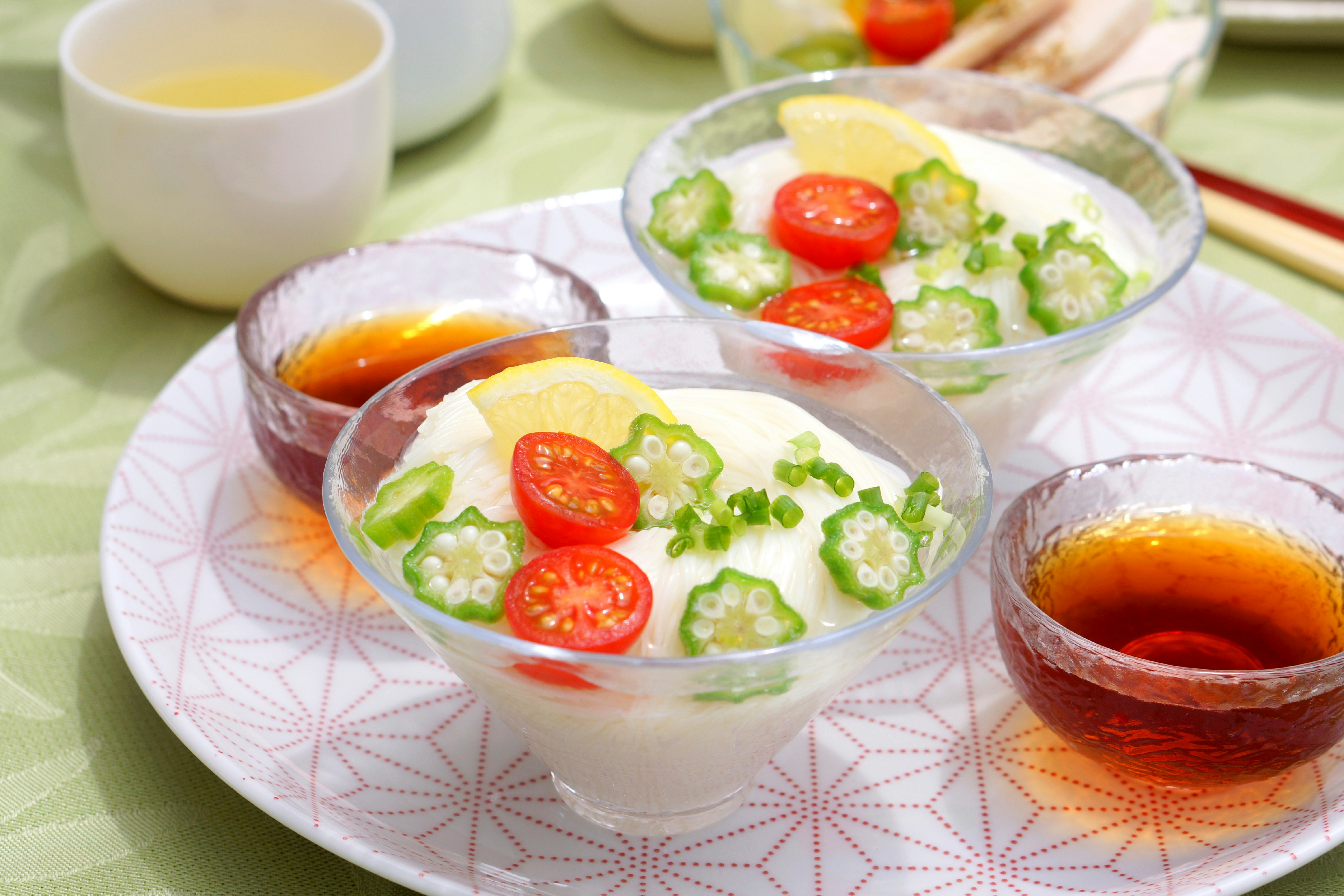 Salatschalen mit Gemüse und Kirschtomaten sowie Dipschalen auf einem Tisch image