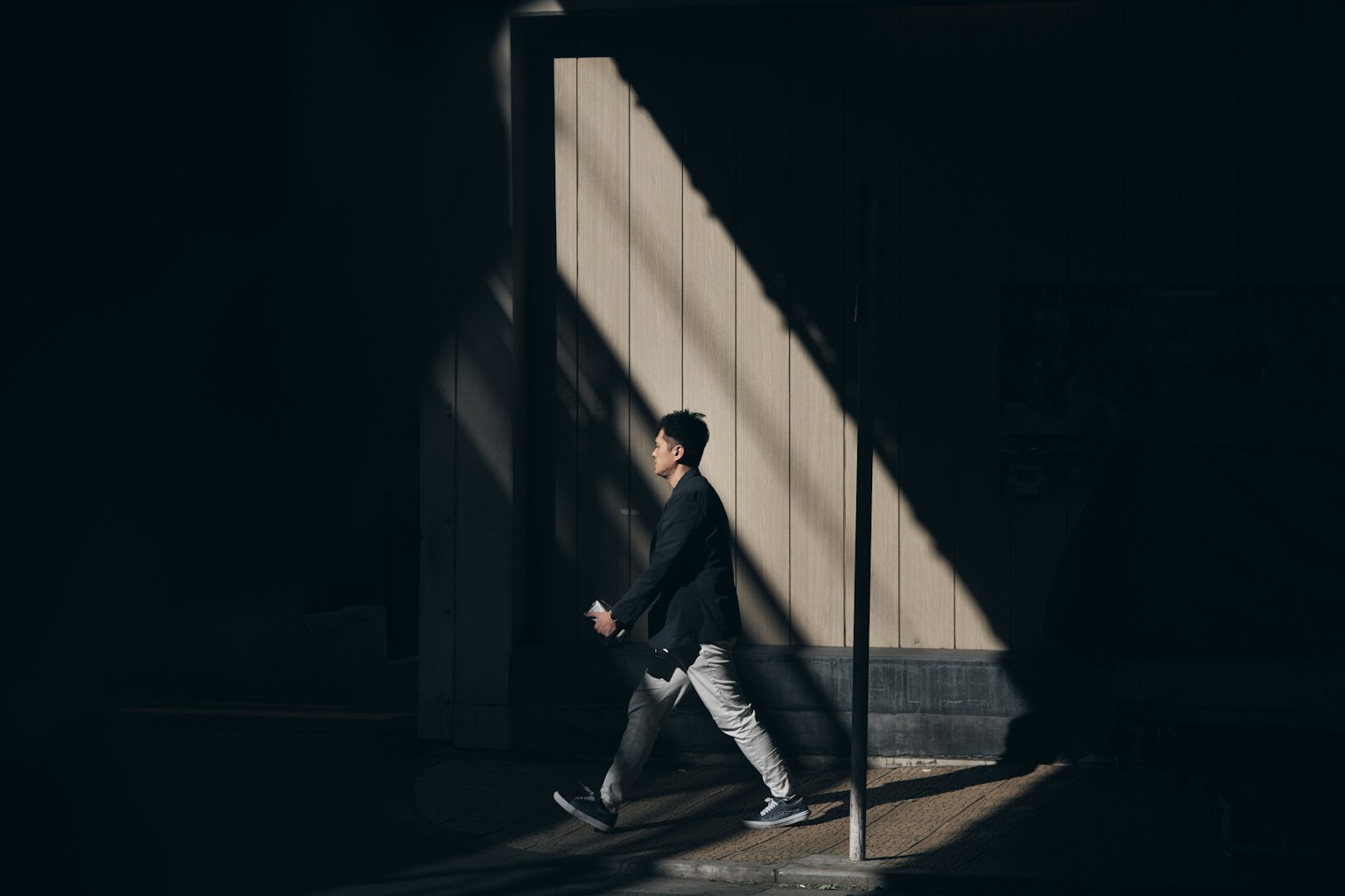 穿過陰影與光條的男人輪廓