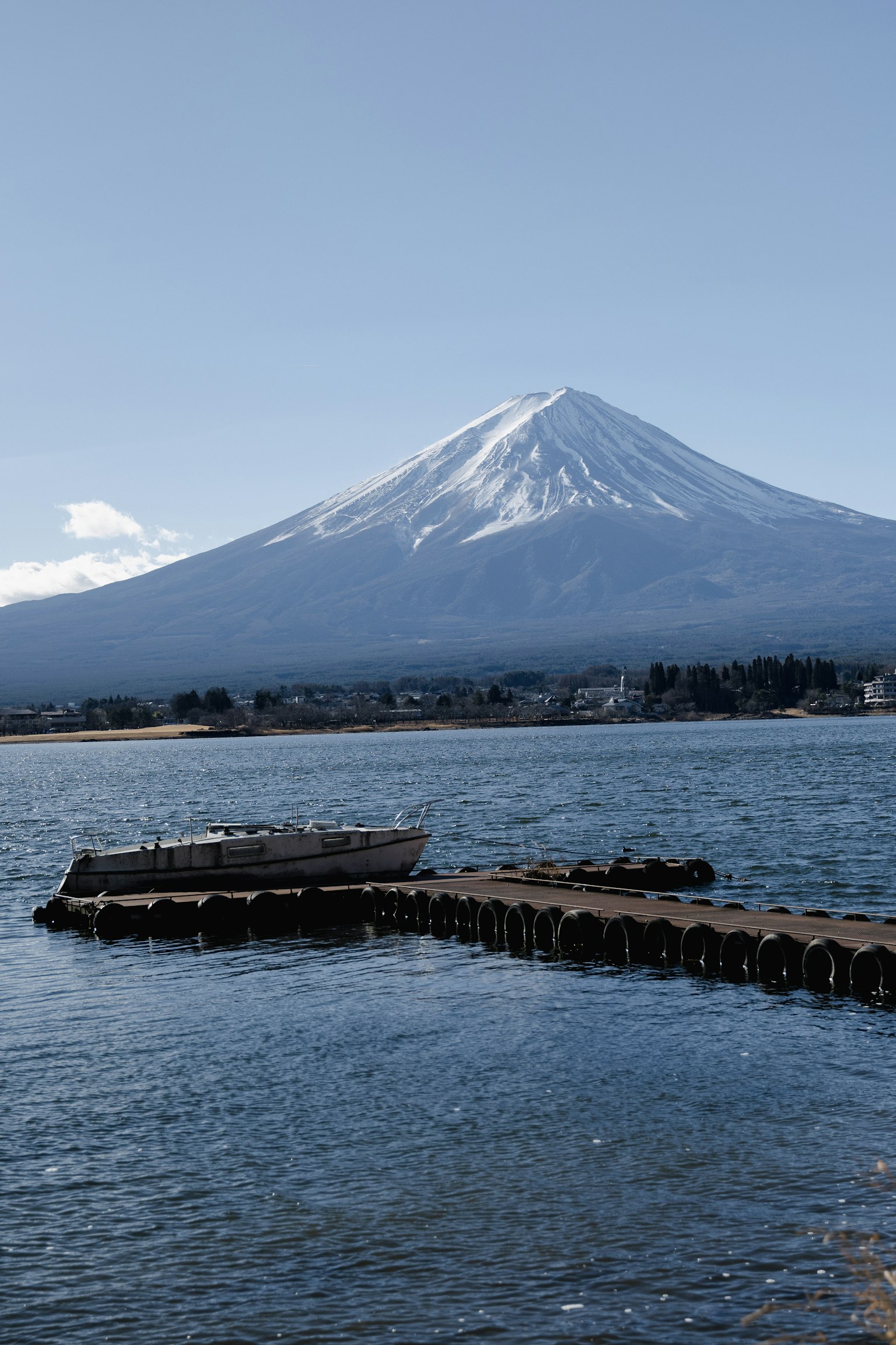 Monte Fuji che svetta su un lago sereno sotto un cielo blu chiaro