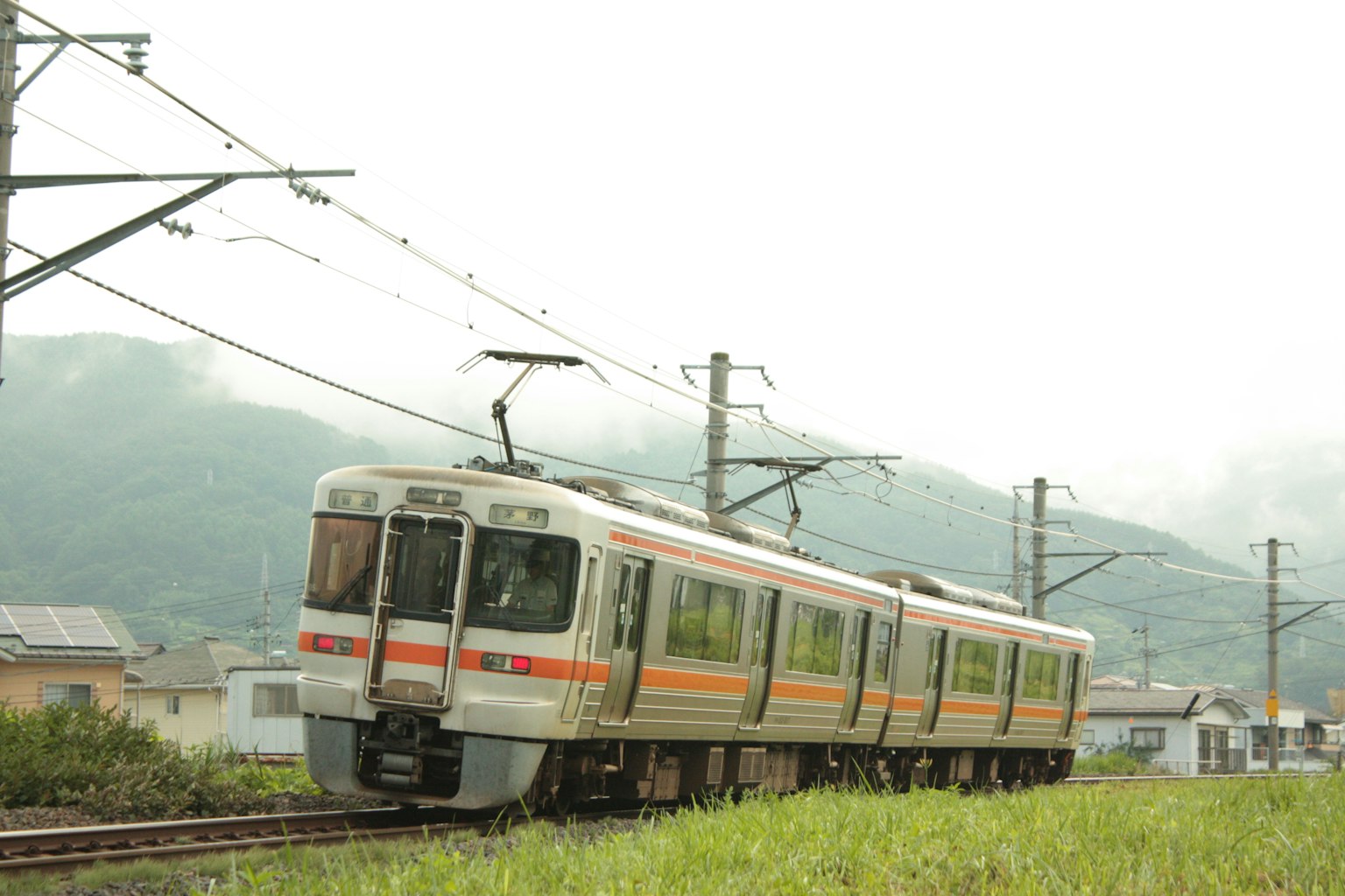 停在綠色草地上的橙色和白色火車