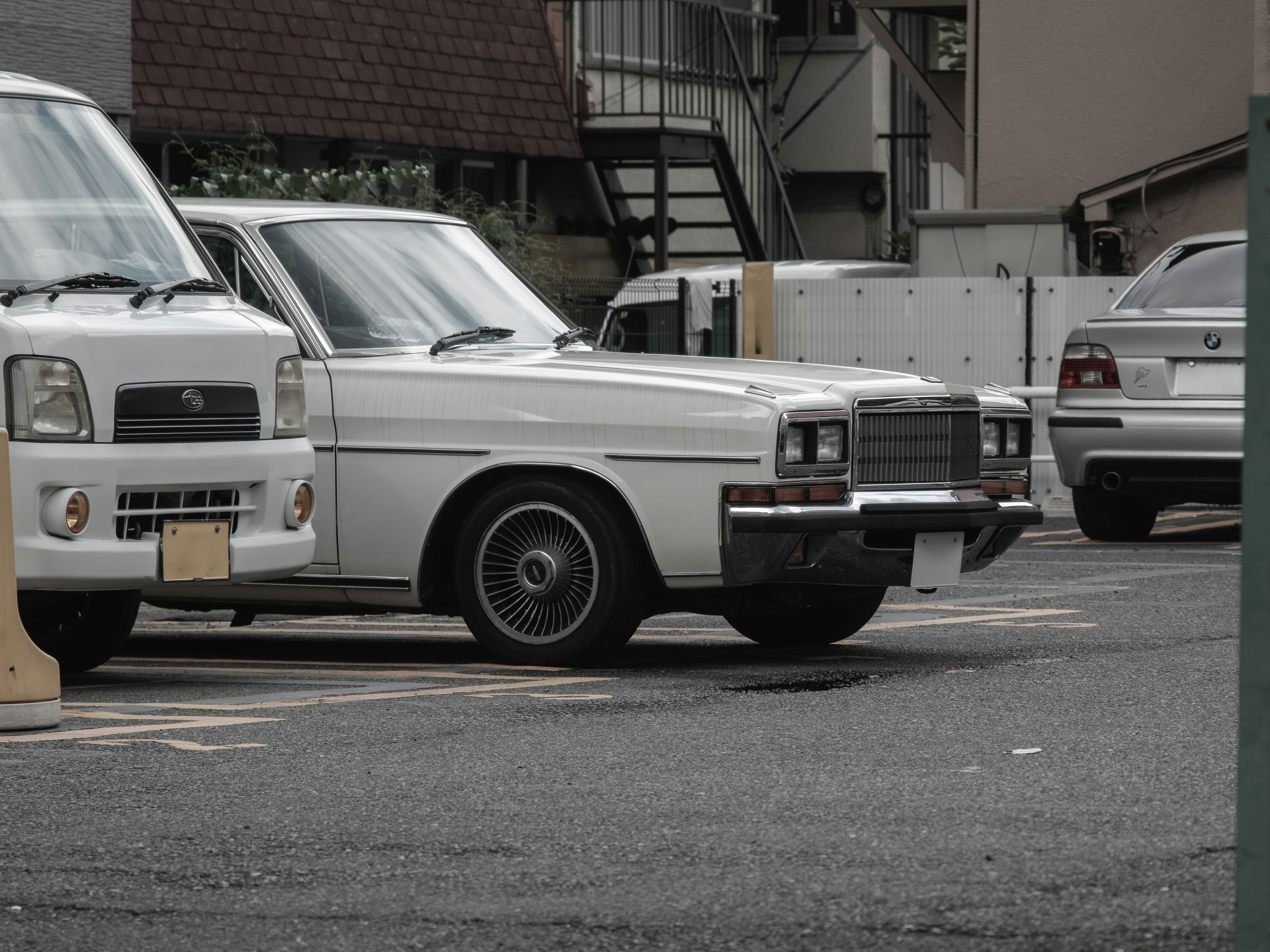 coches clásicos estacionados a lo largo de una calle estrecha