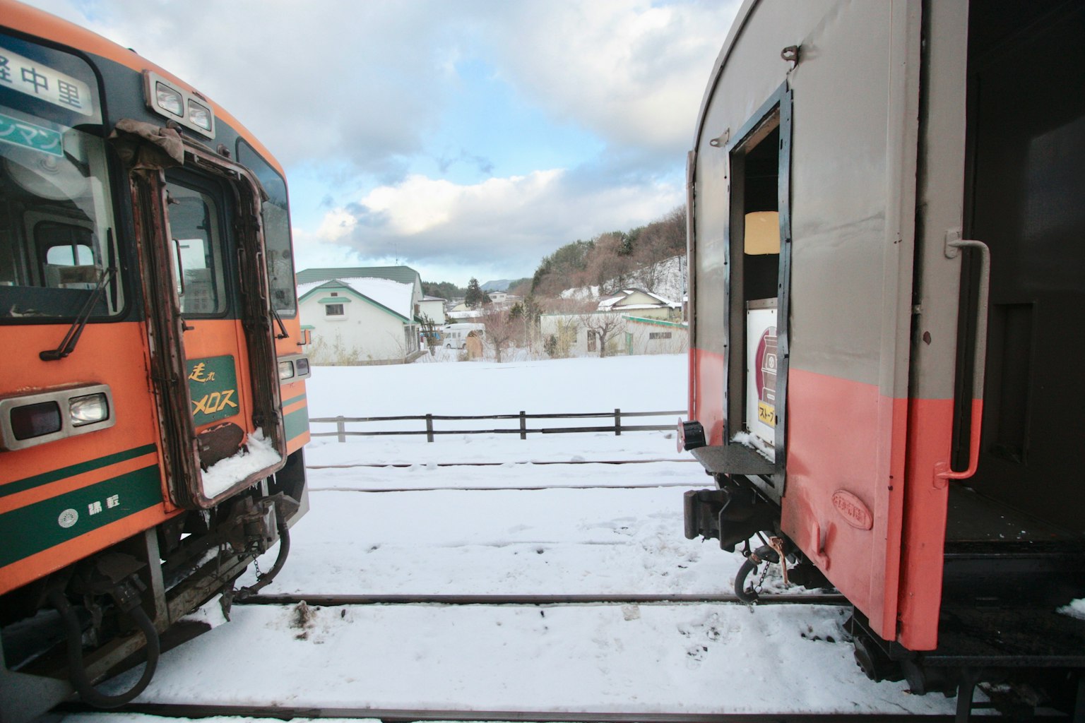 รถไฟสองขบวนจอดอยู่ในหิมะพร้อมภูมิทัศน์ที่สวยงาม
