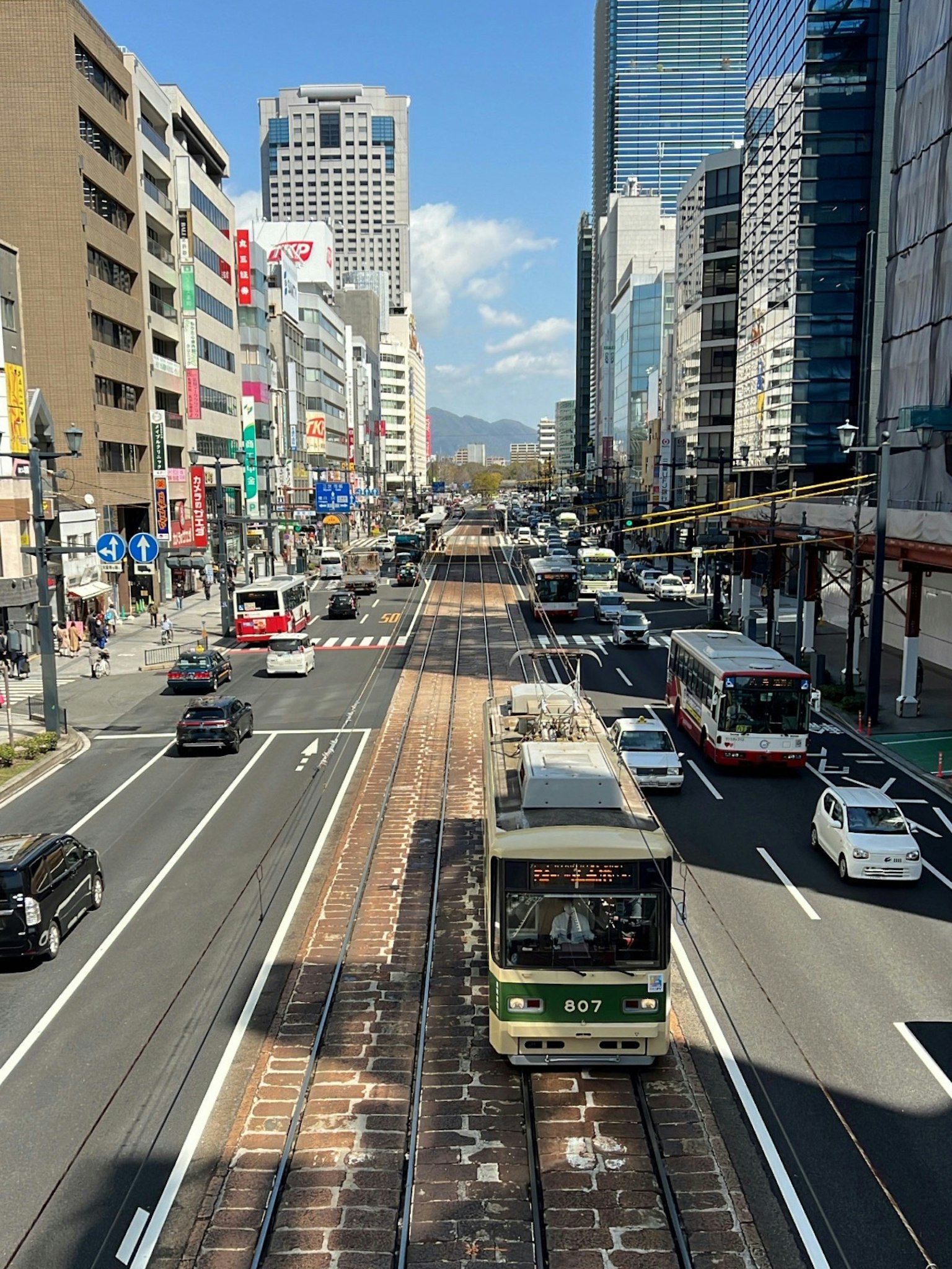 Scène urbaine avec un tram et des voitures sur une rue animée gratte-ciels en arrière-plan
