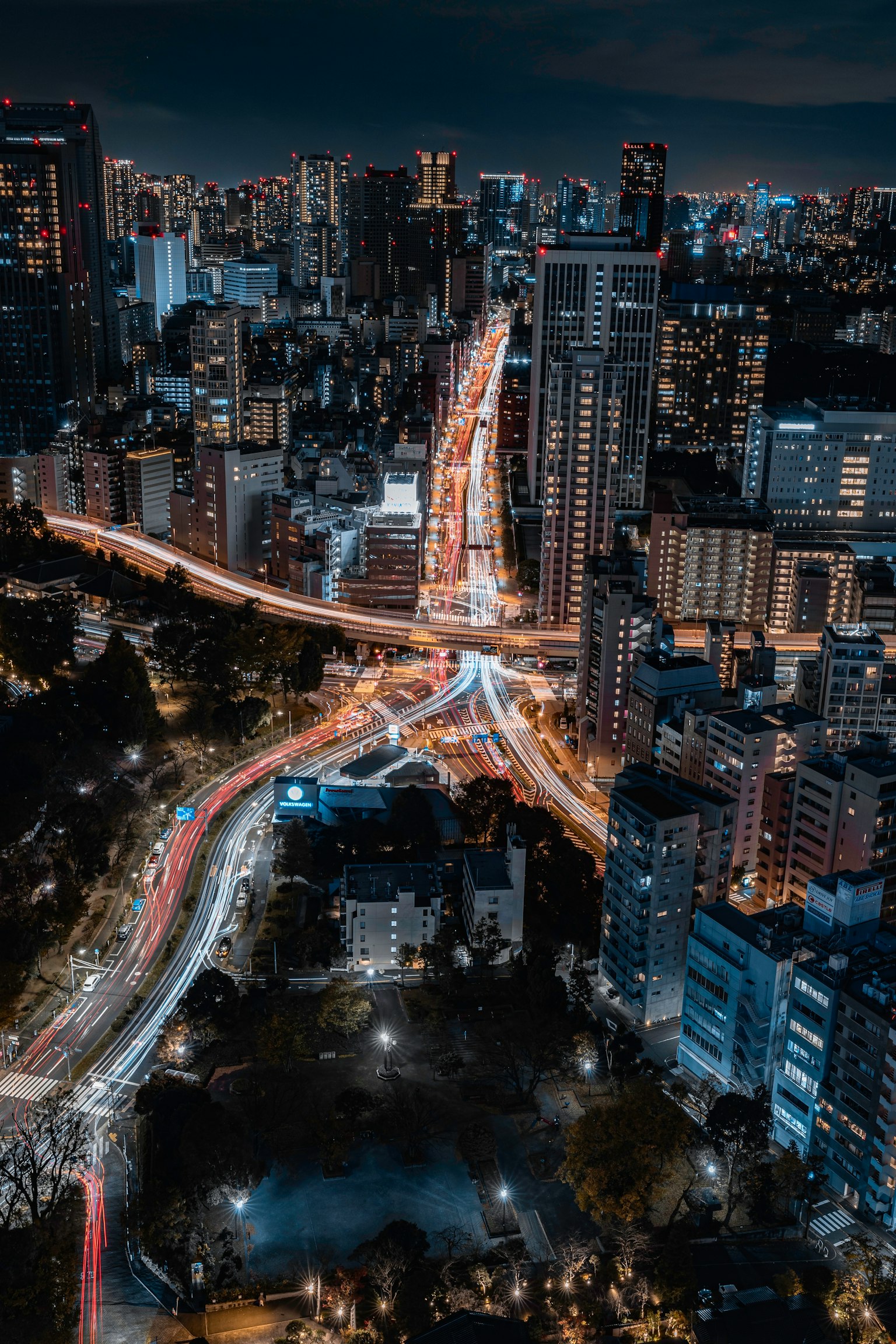 Paesaggio urbano notturno con grattacieli strade incrociate e tracce di luce
