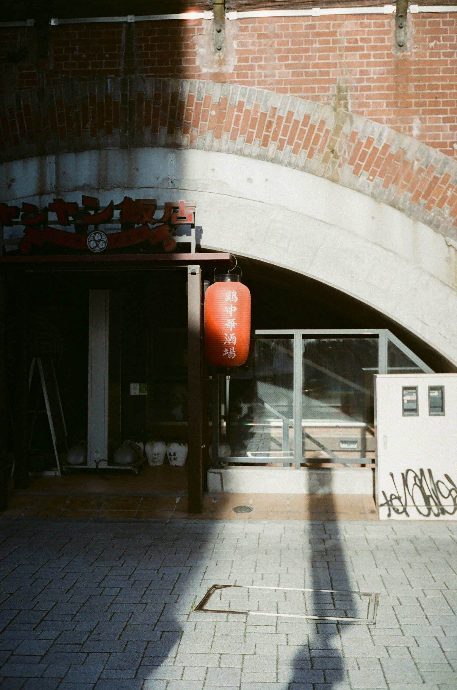 Une entrée de magasin avec une lanterne rouge sous une arche