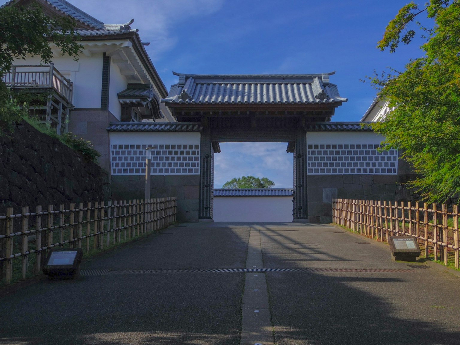 Puerta japonesa tradicional con vista al jardín bajo un cielo azul