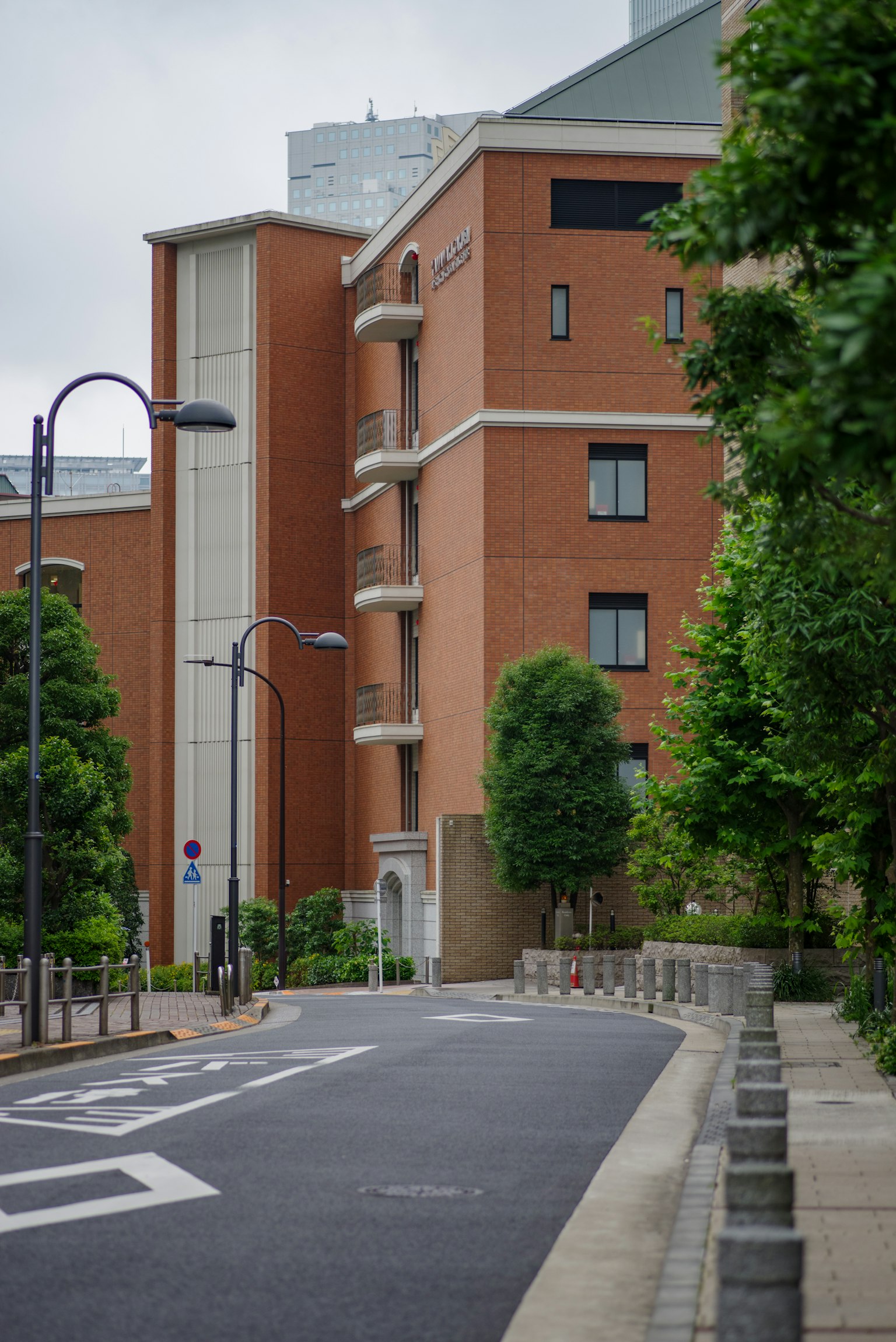 Eine Straßenansicht mit einem roten Backsteingebäude und grünen Bäumen
