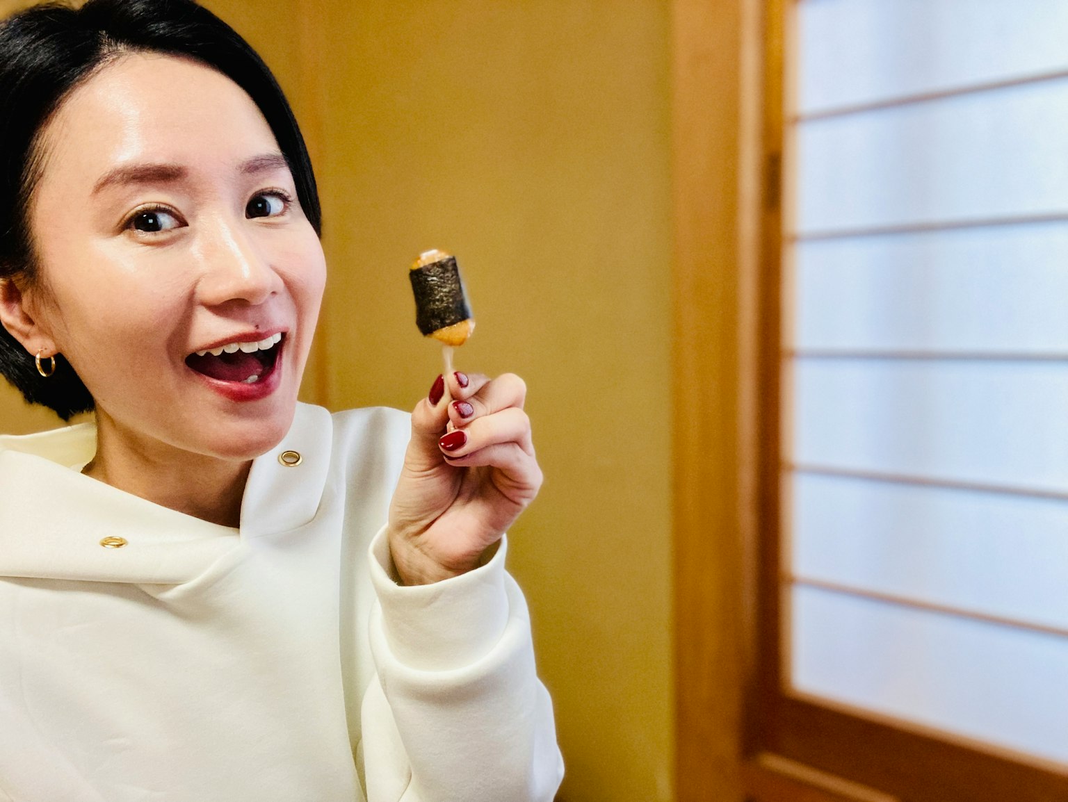 Une femme souriante tenant une glace sur un bâton