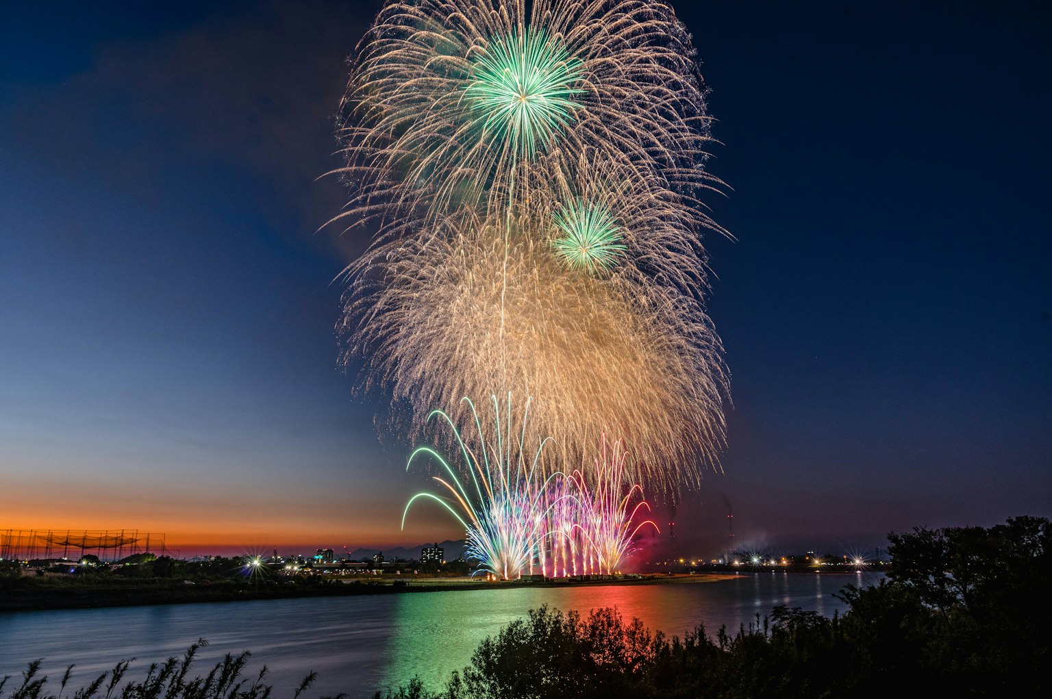 夜空中繽紛的煙火表演 彩色光芒映照在水面上