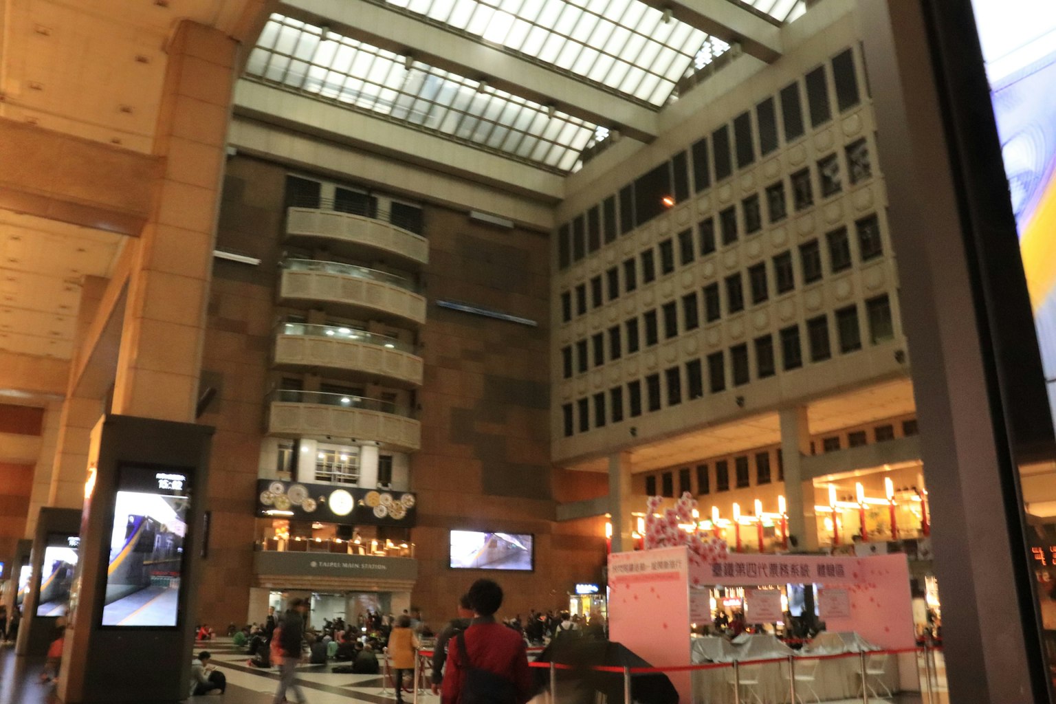 Interior de un edificio moderno con personas y un techo de vidrio brillante
