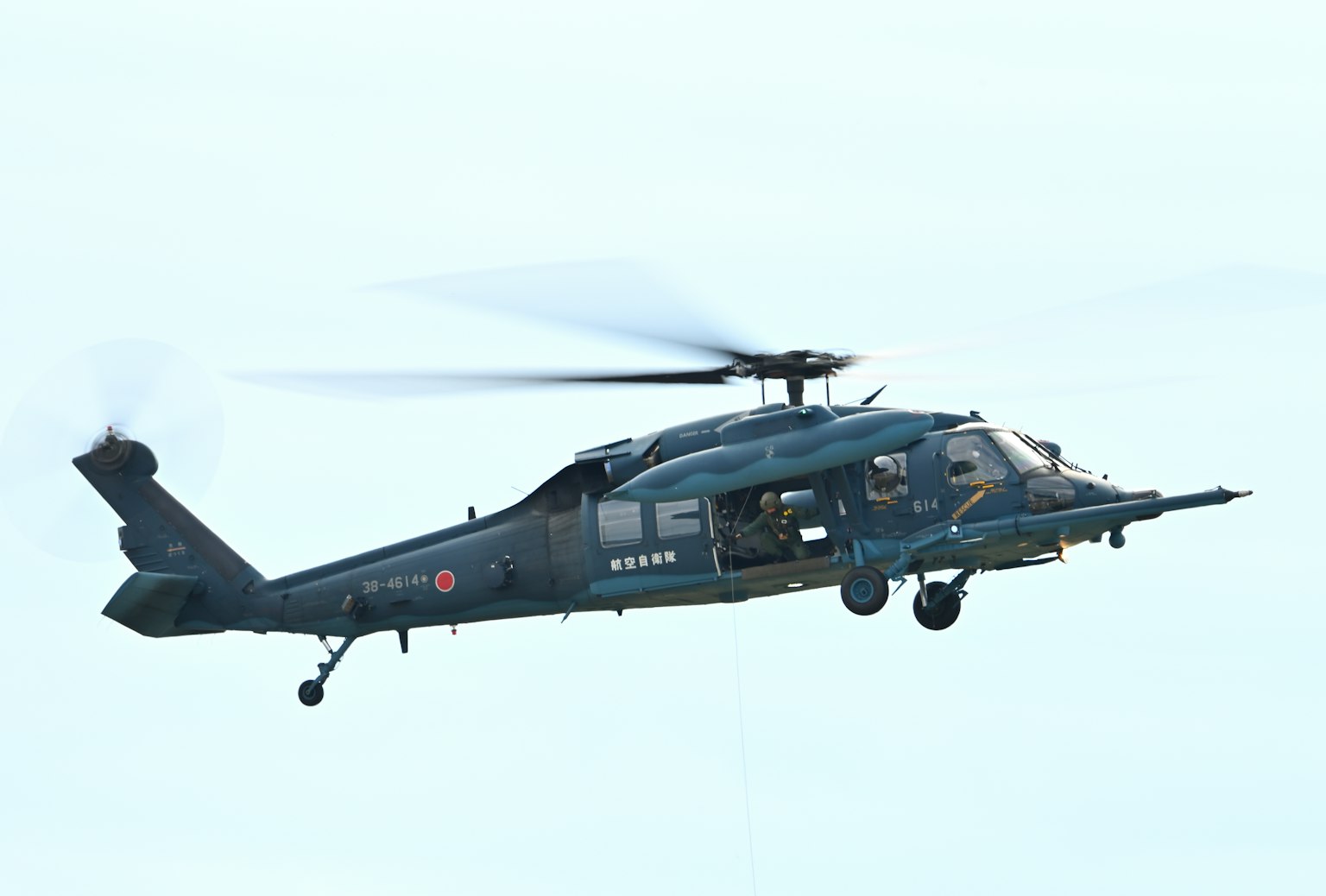 Image of a helicopter in flight with a dark body and spinning rotors