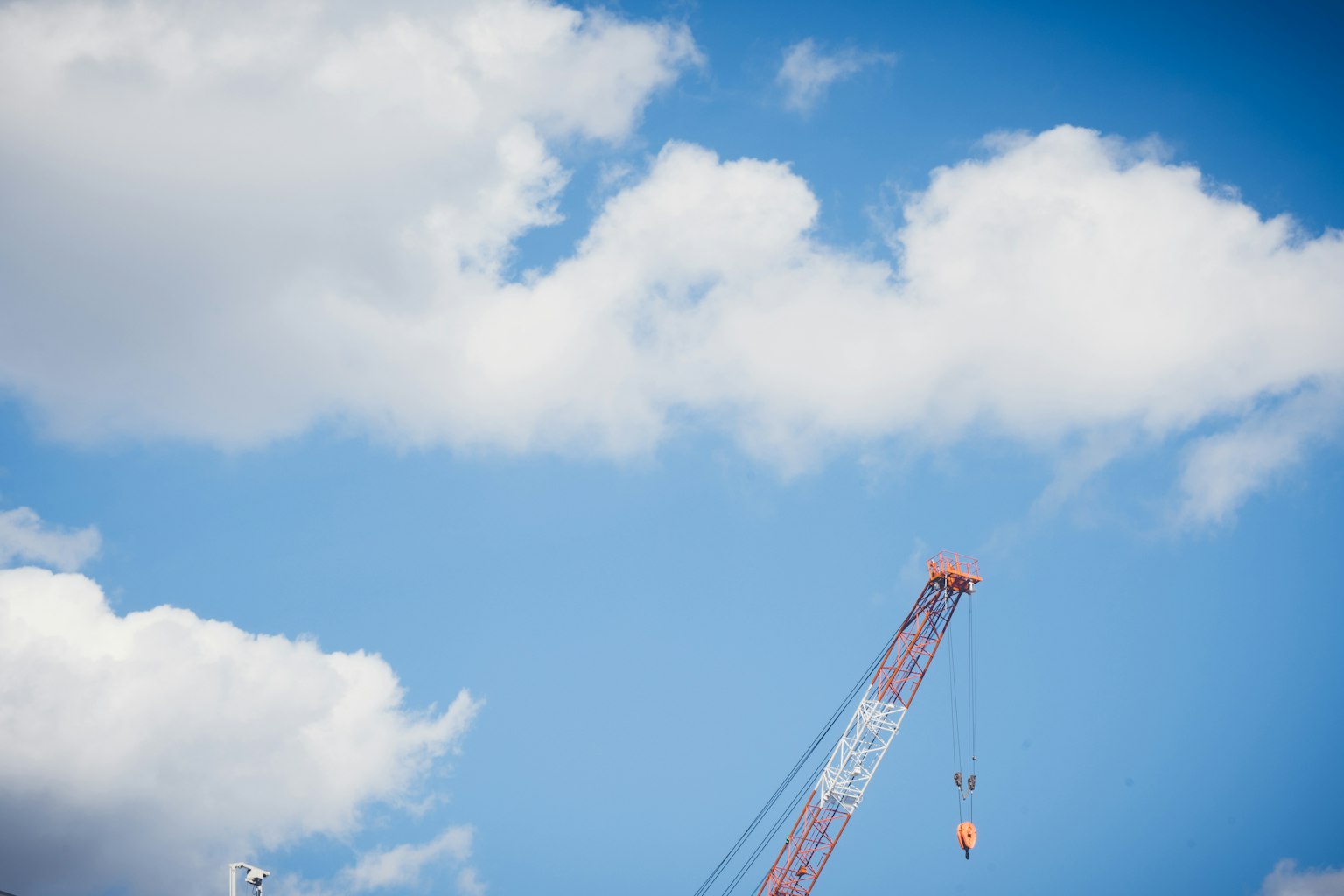 Grue contre un ciel bleu clair avec des nuages blancs duveteux