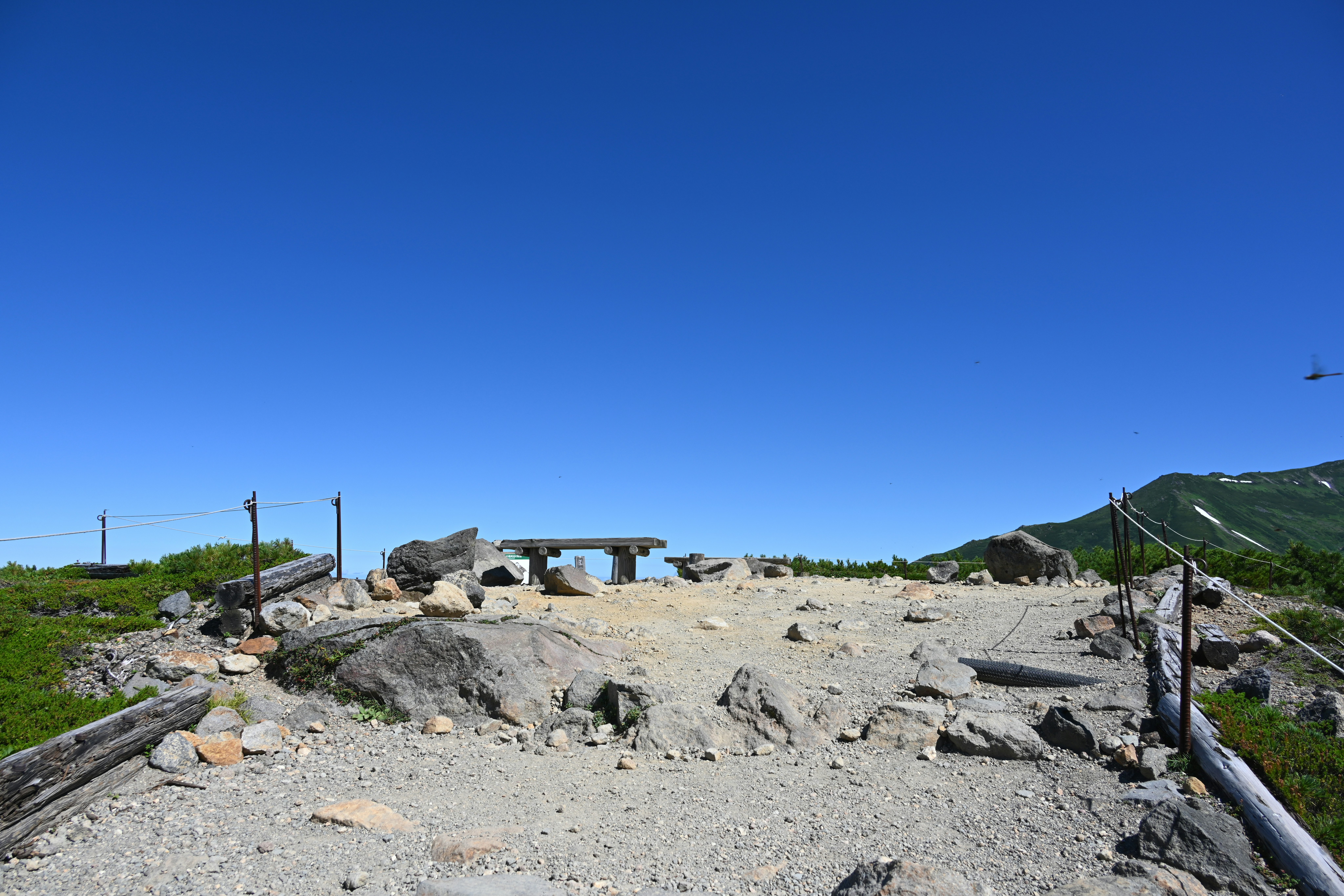 sentiero di montagna roccioso e punto panoramico sotto un cielo azzurro