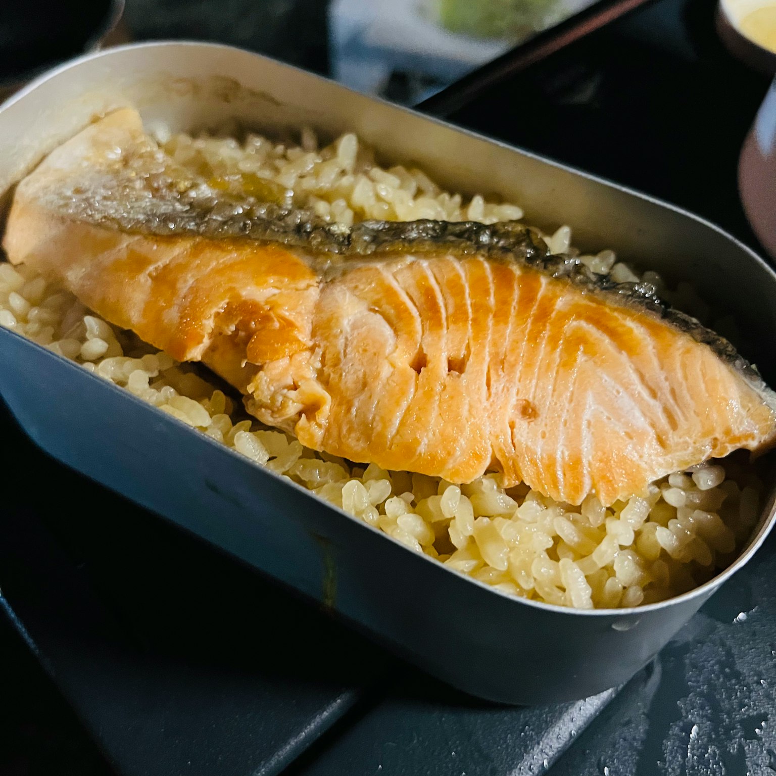 Saumon grillé sur du riz dans une boîte à bento