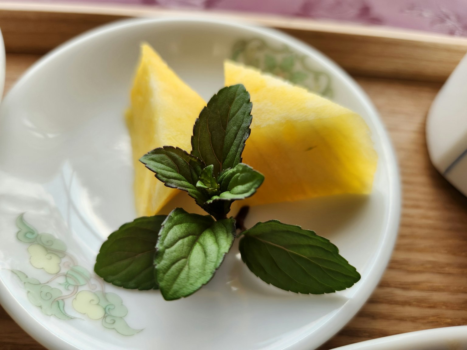 Irisan nanas dengan daun mint segar di piring dekoratif