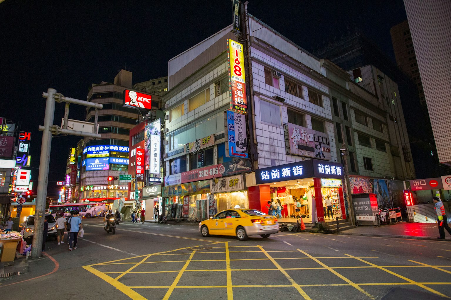 夜晚街角有黄色出租车和霓虹灯牌